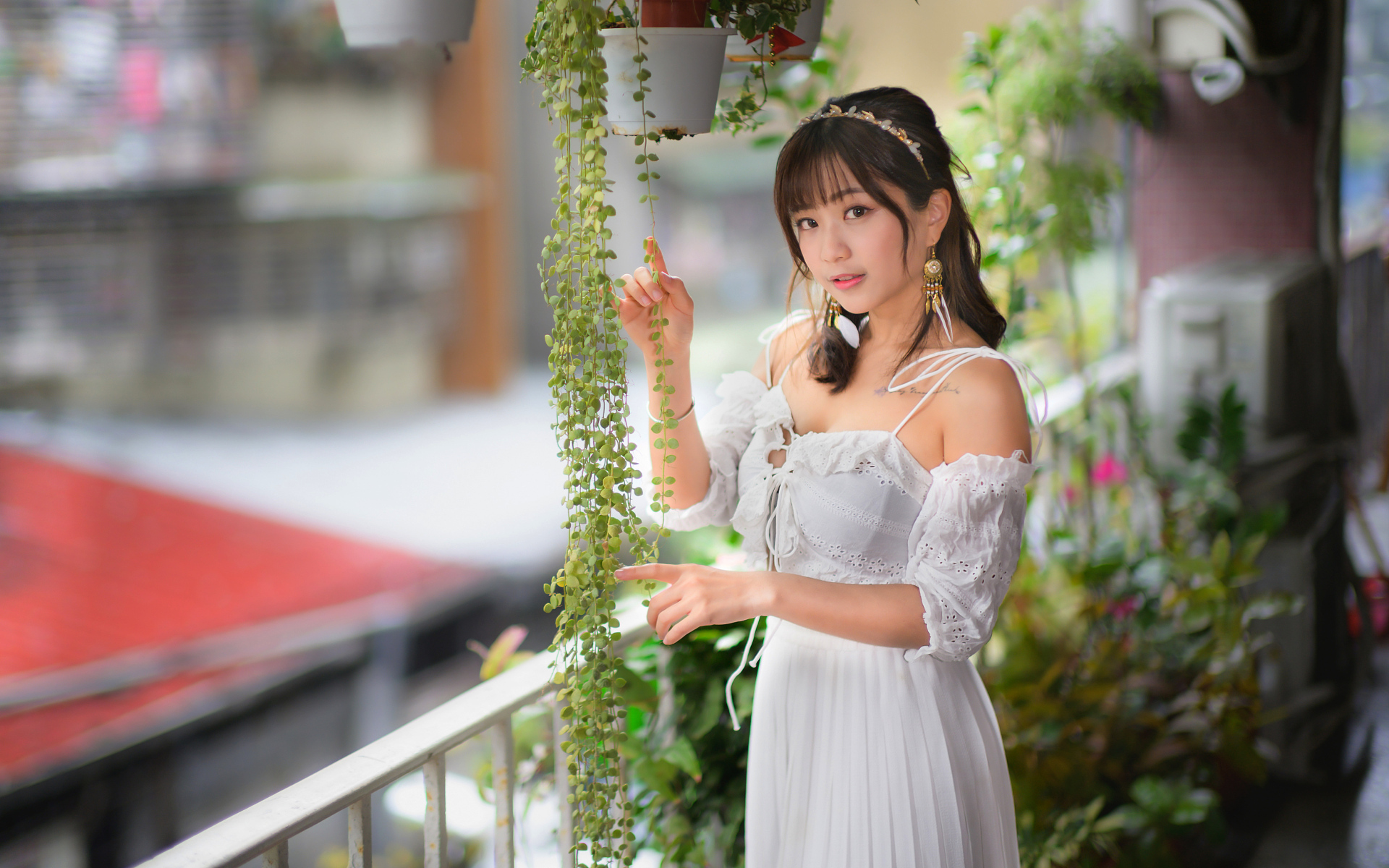 Молодая азиатка в белом платье у растений