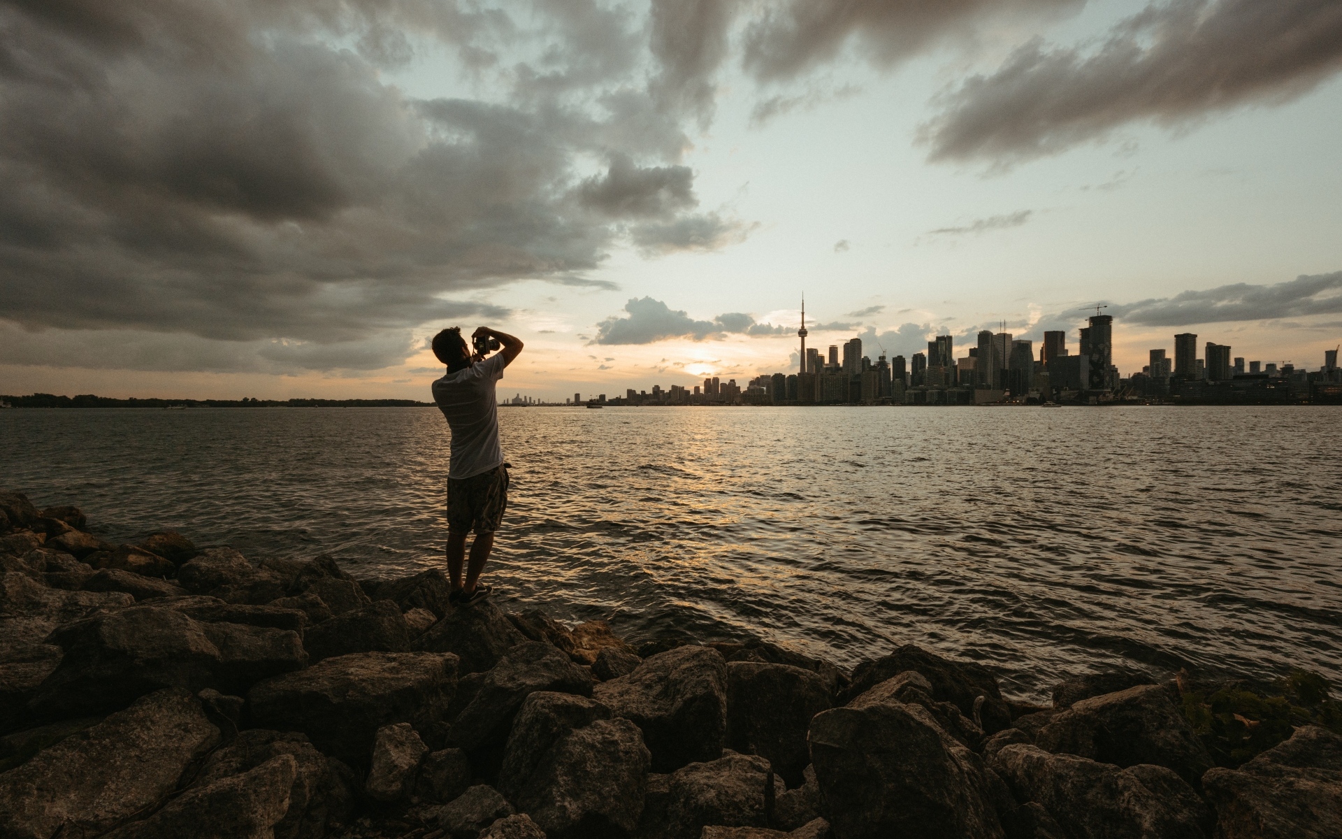 Мужчина делает фото города у моря