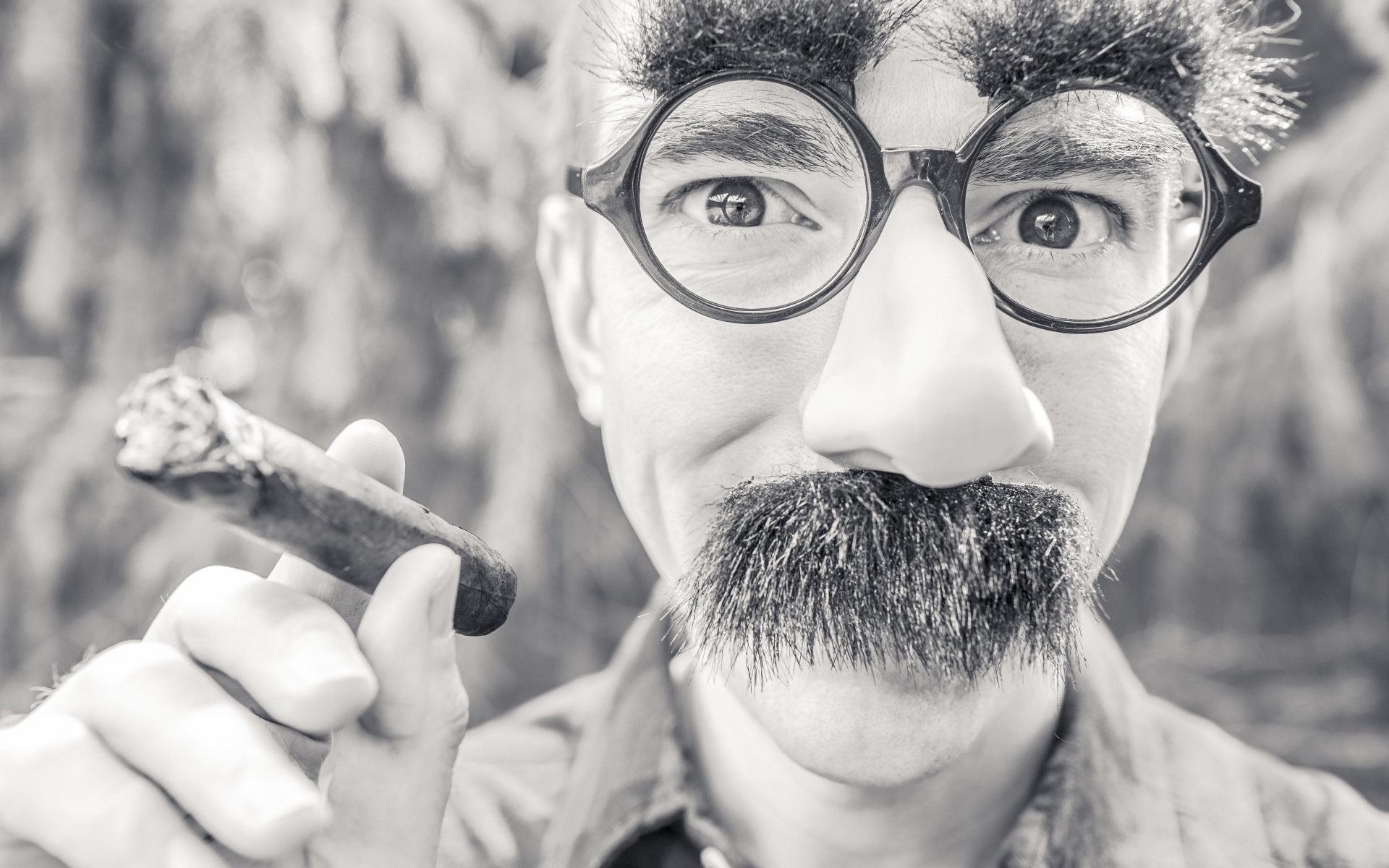 Мужчина в очках с сигарой в руке