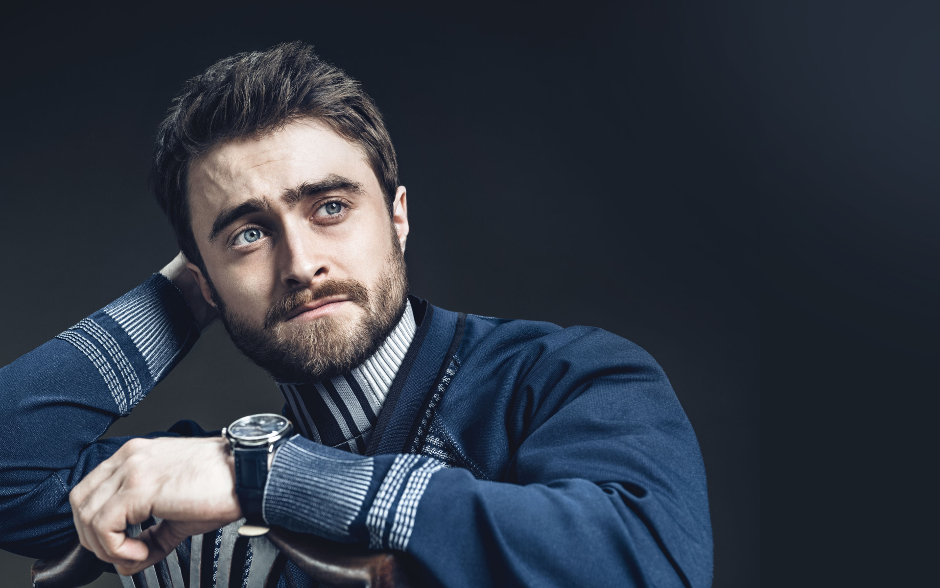 Актер Дэниел Рэдклифф в свитере на сером фоне