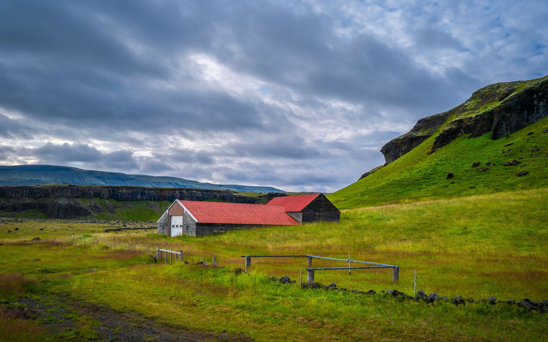 Дом у покрытой зеленью поры под грозовым небом