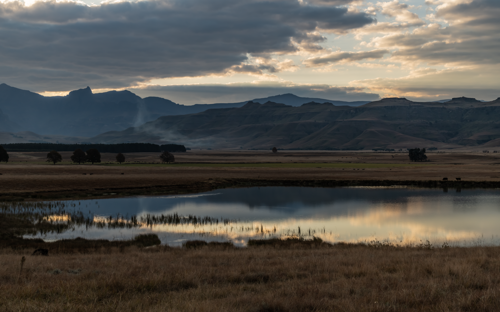 Грозовые облака отражаются в воде озера в горах 