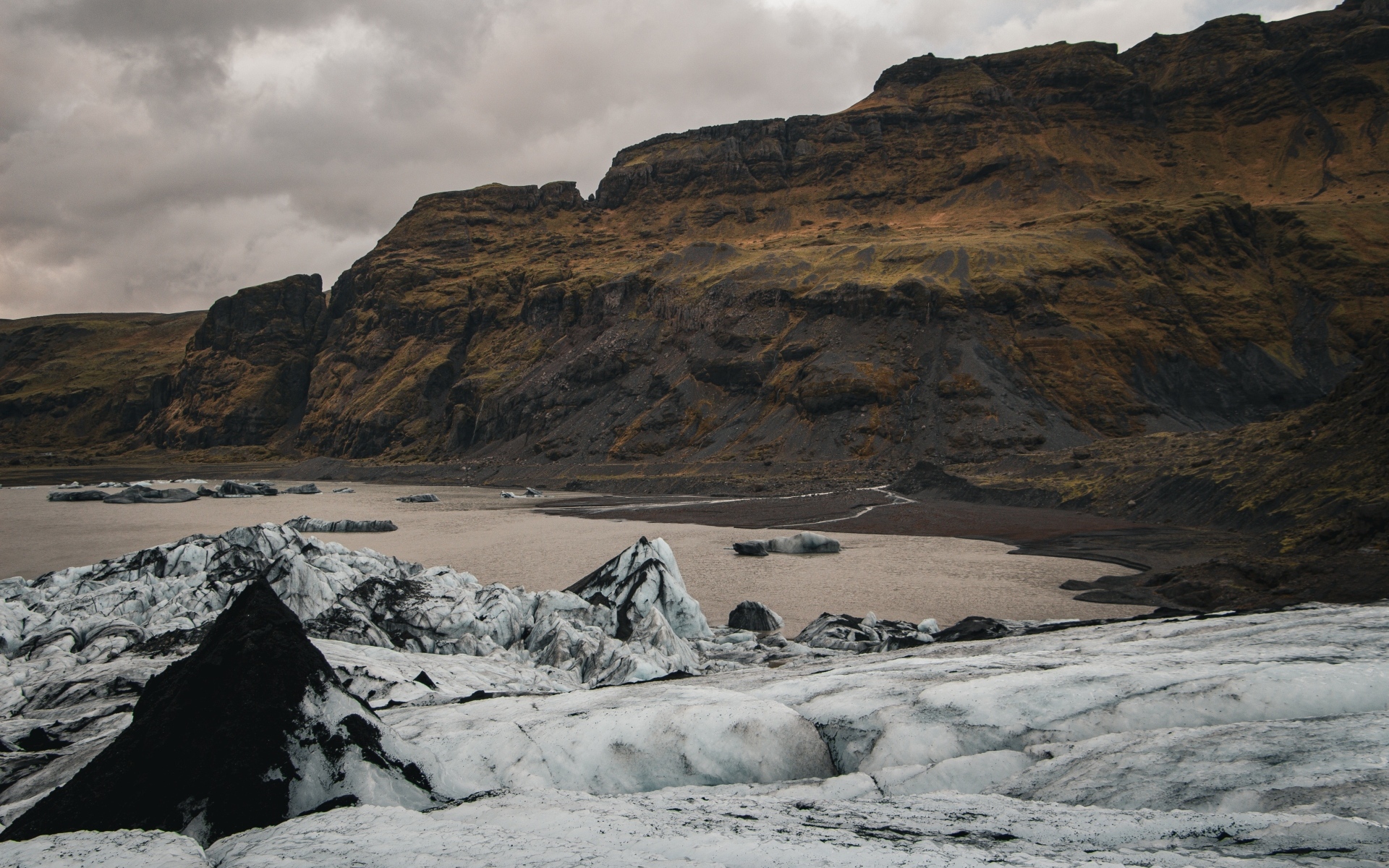 Холодный грязный снег на берегу моря у гор 