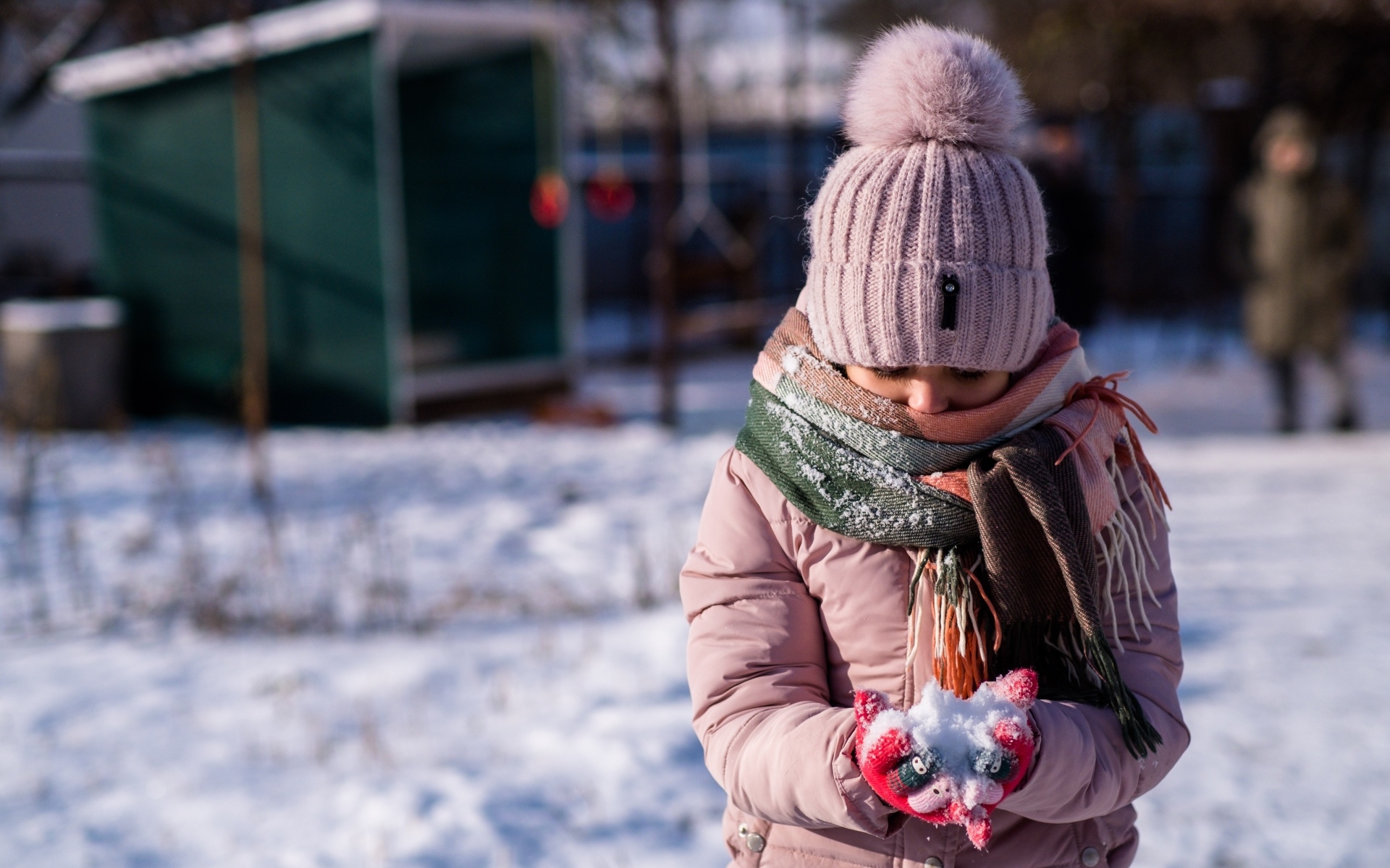 Девочка держит снег в руках зимой