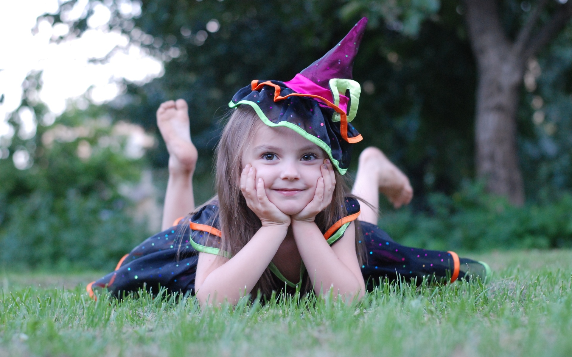 Девочка в костюме лежит на зеленой траве