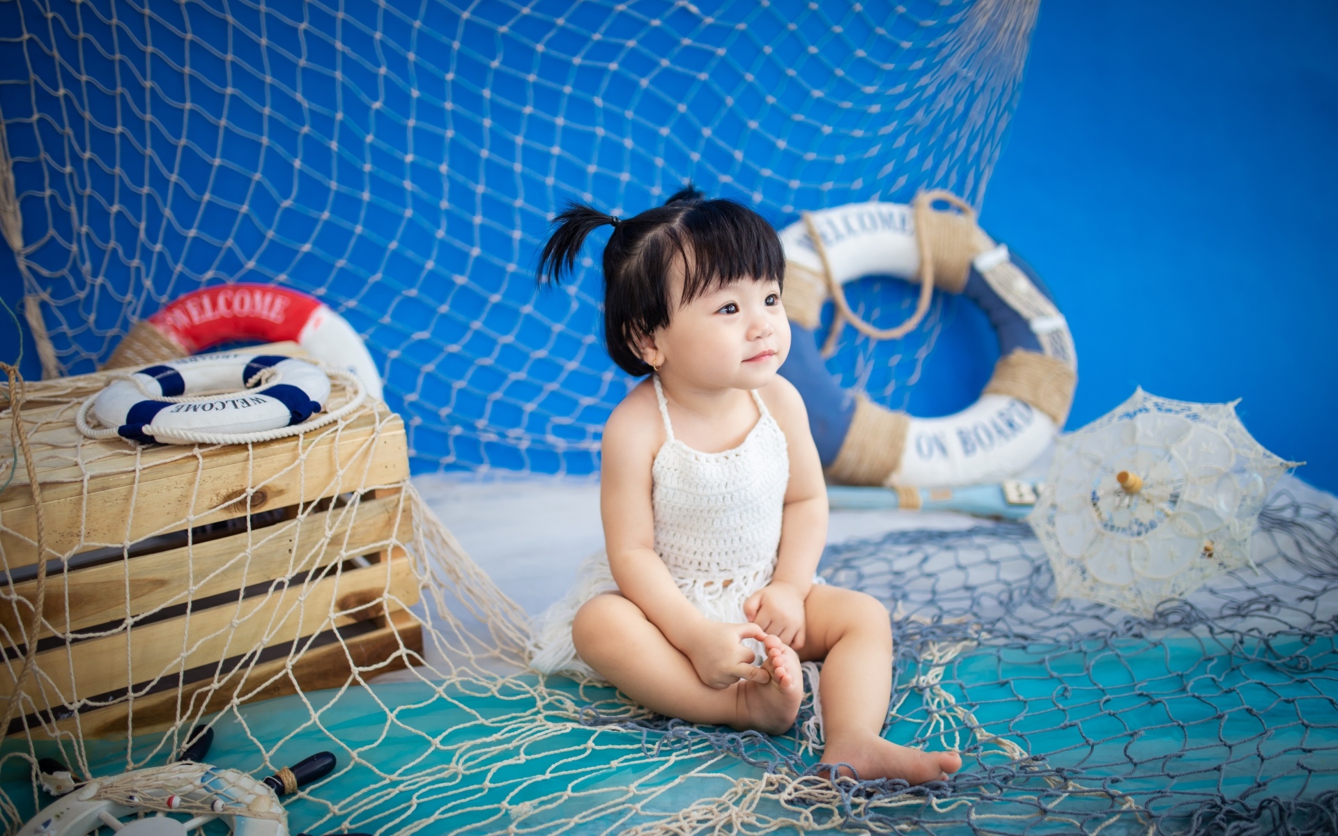 Маленькая девочка азиатка со  спасательным кругом и сетью 