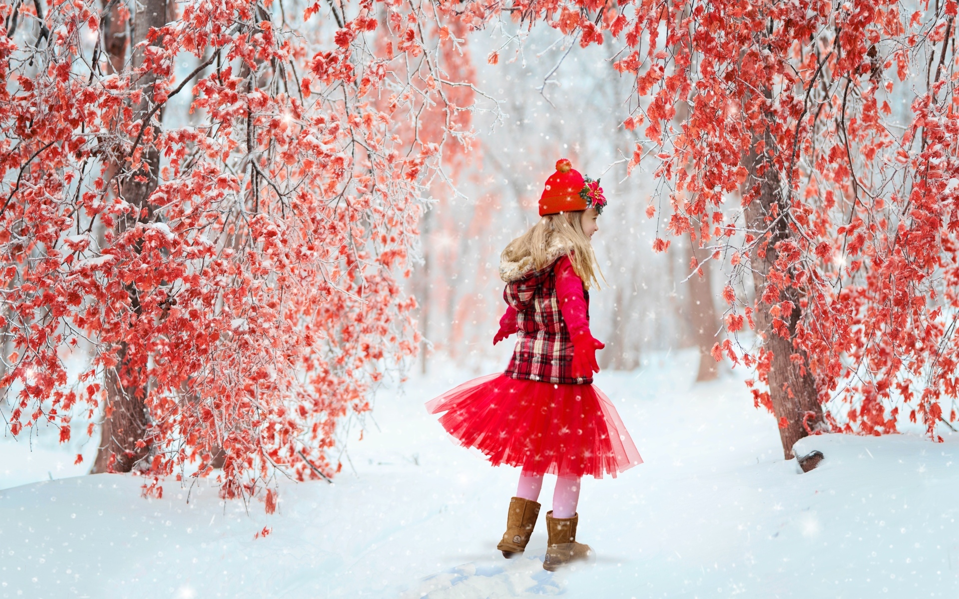 Маленькая девочка в красном платье в зимнем лесу