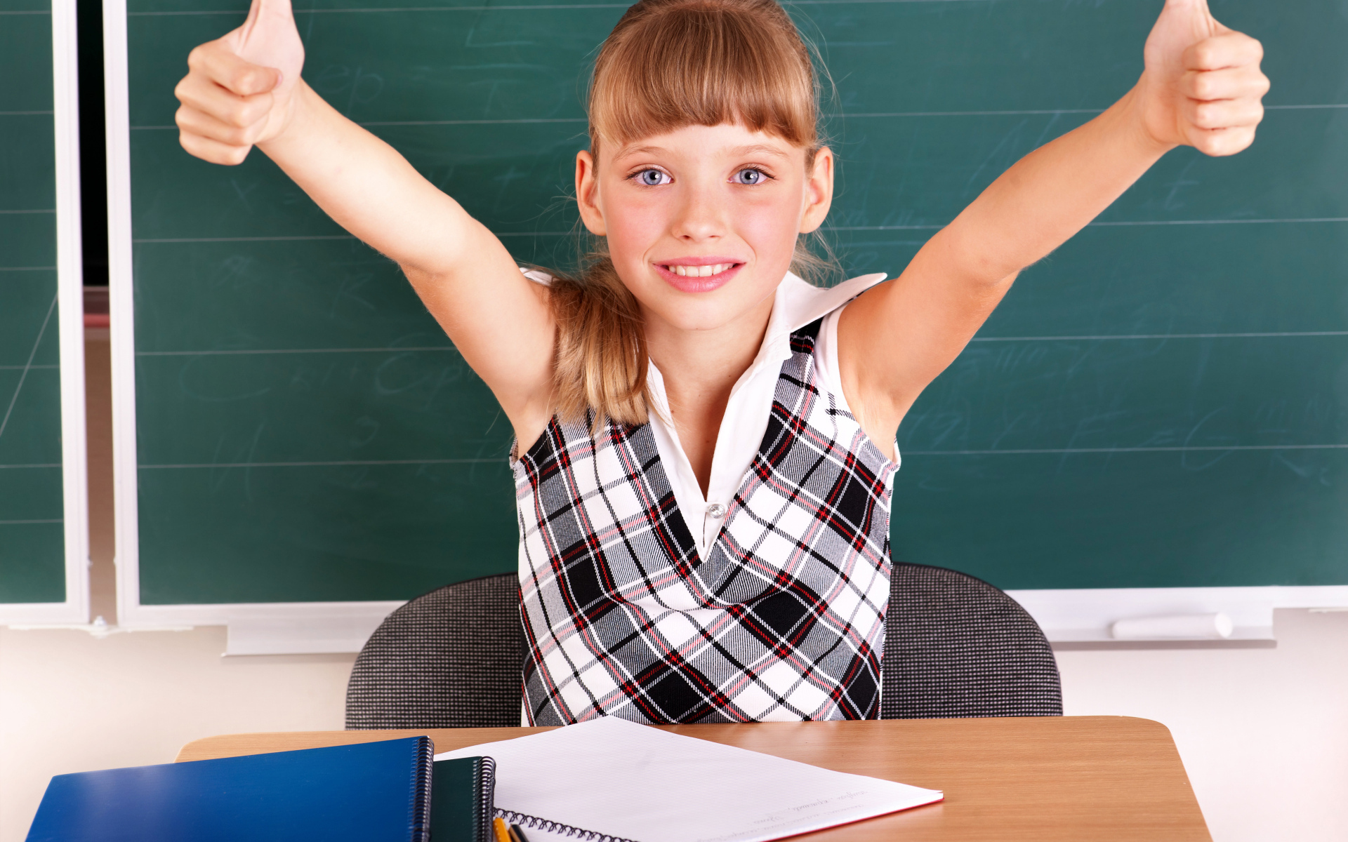 Маленькая девочка школьница в классе за партой 