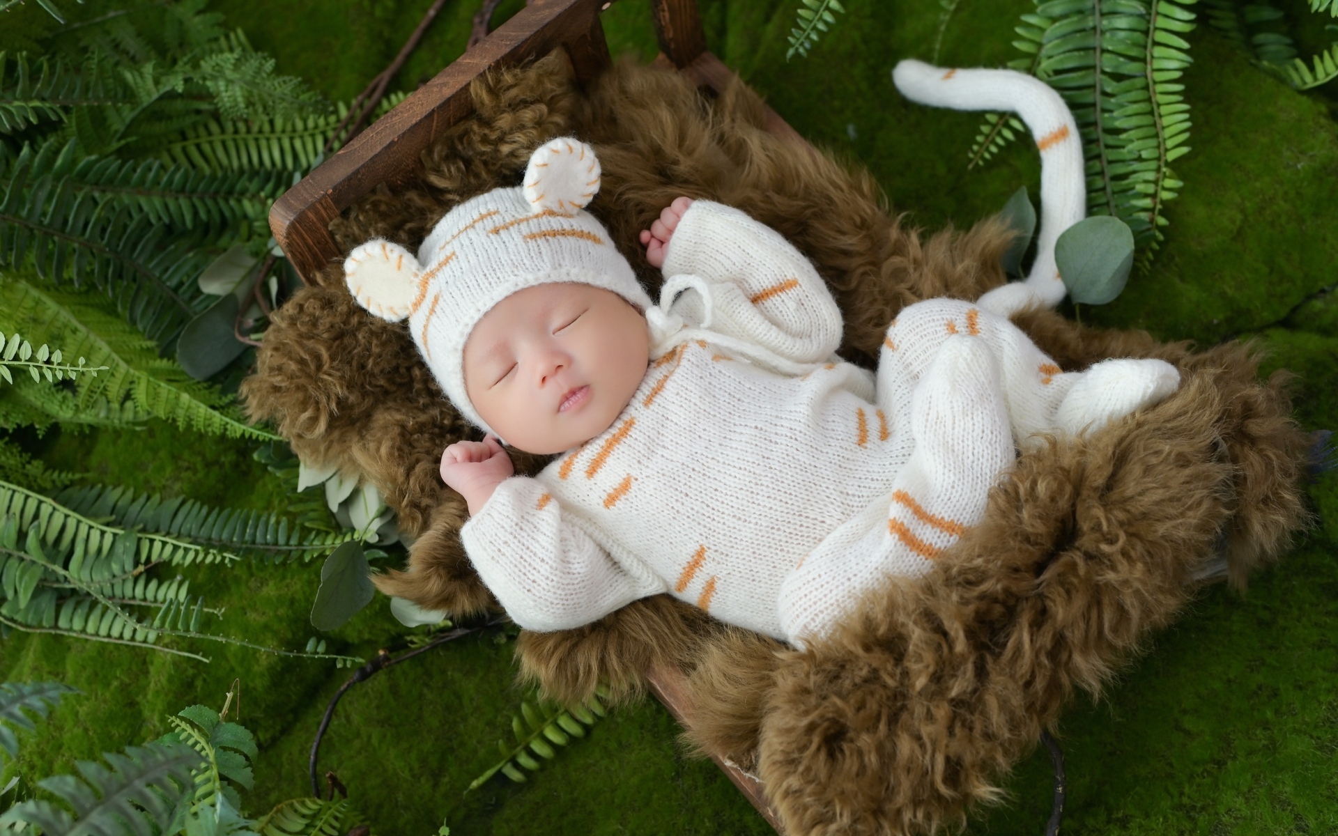 Спящий новорожденный ребенок в костюме тигренка