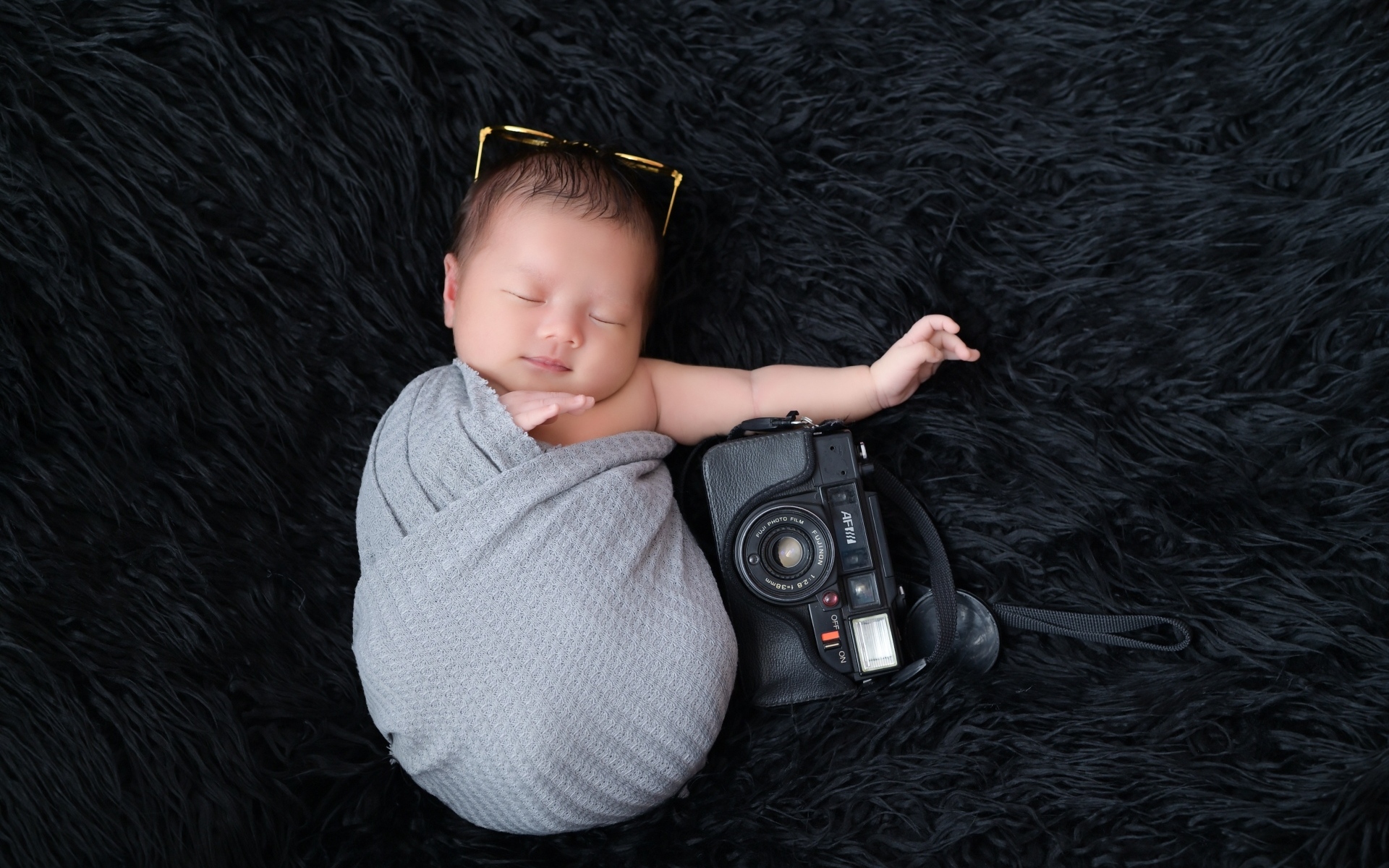 Спящий новорожденный малыш с фотоаппаратом