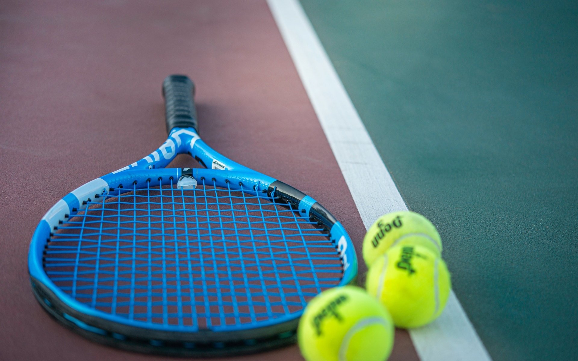 Ракетка и теннисные  мячи на корте