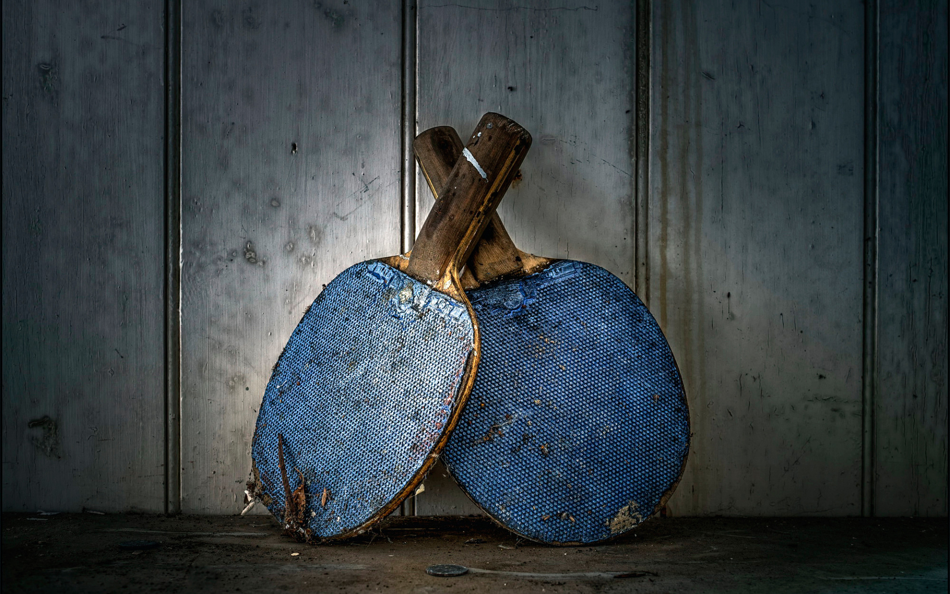 Две старые ракетки для настольного тенниса у стены