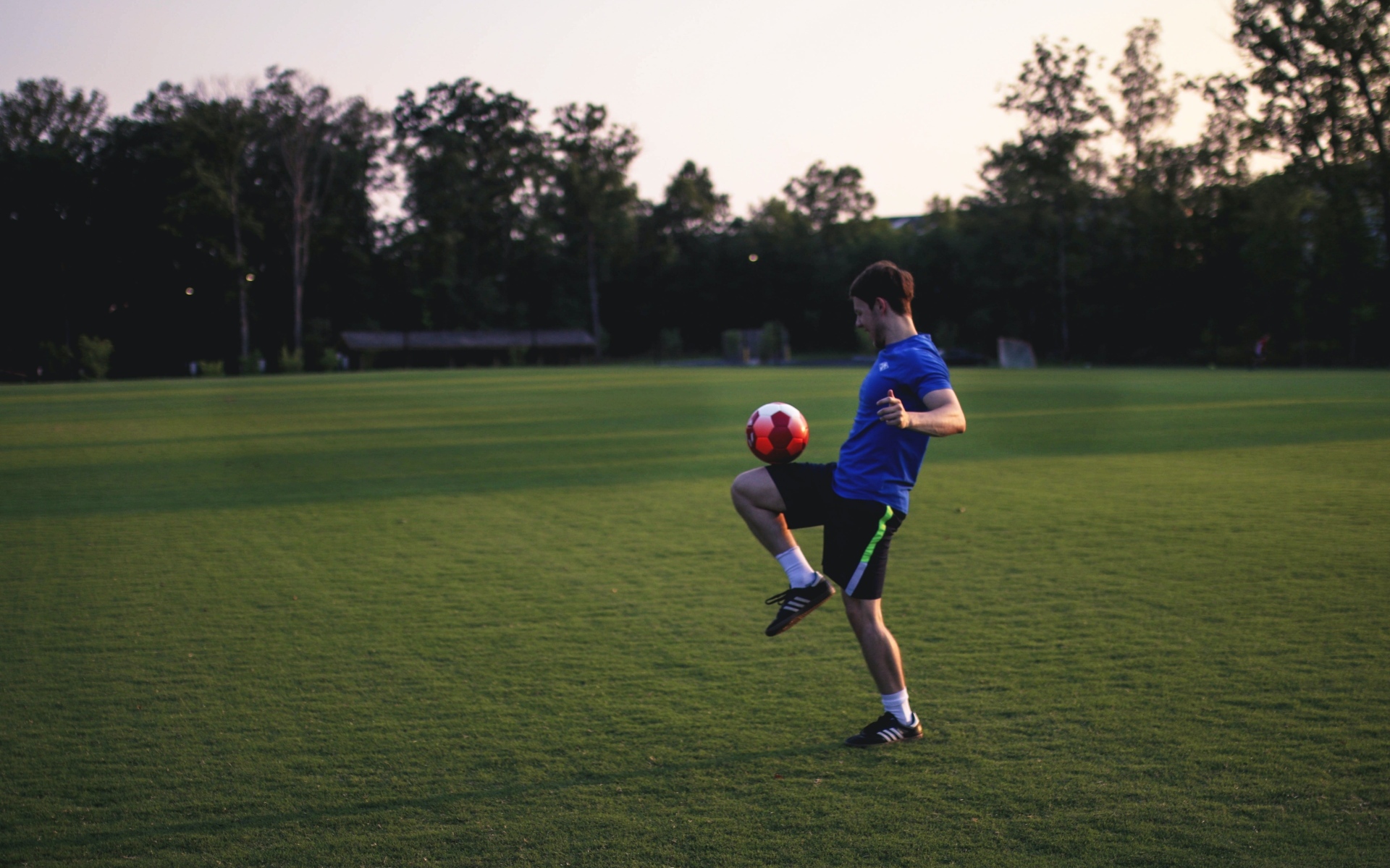 Мужчина футболист с мячом на поле