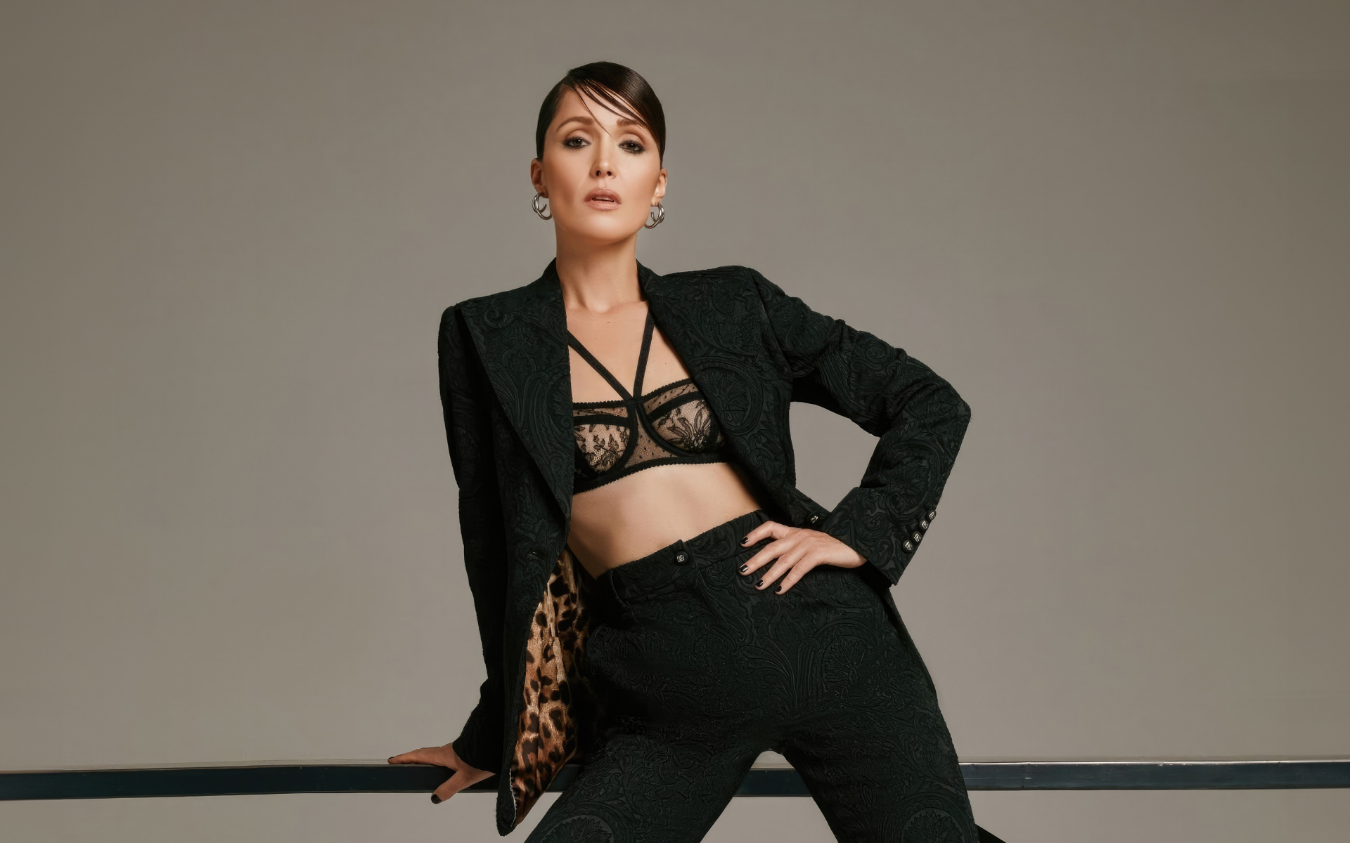 Эффектная актриса Роуз Бёрн в черном костюме на сером фоне