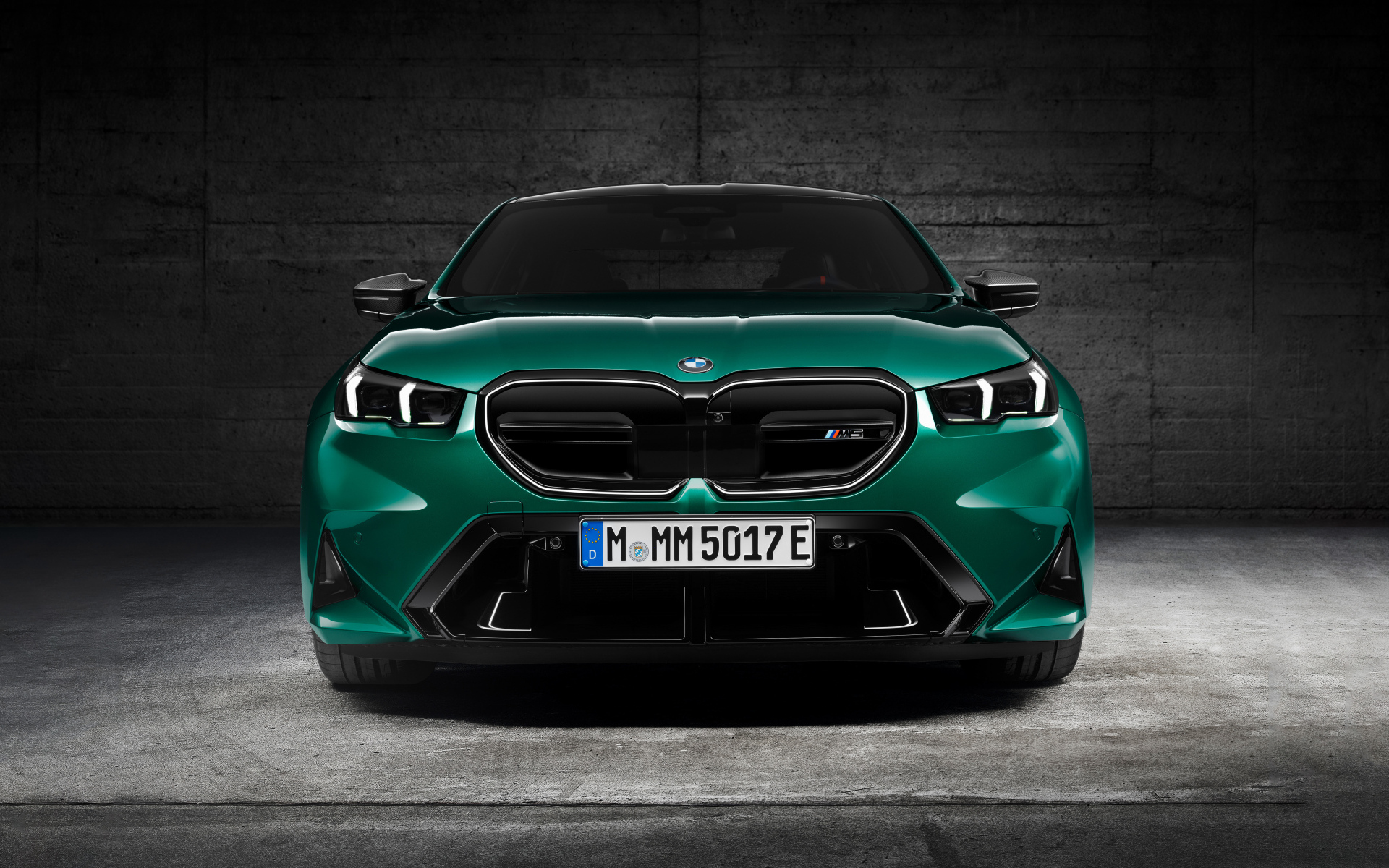 Зеленый автомобиль BMW M5 2024  года вид спереди