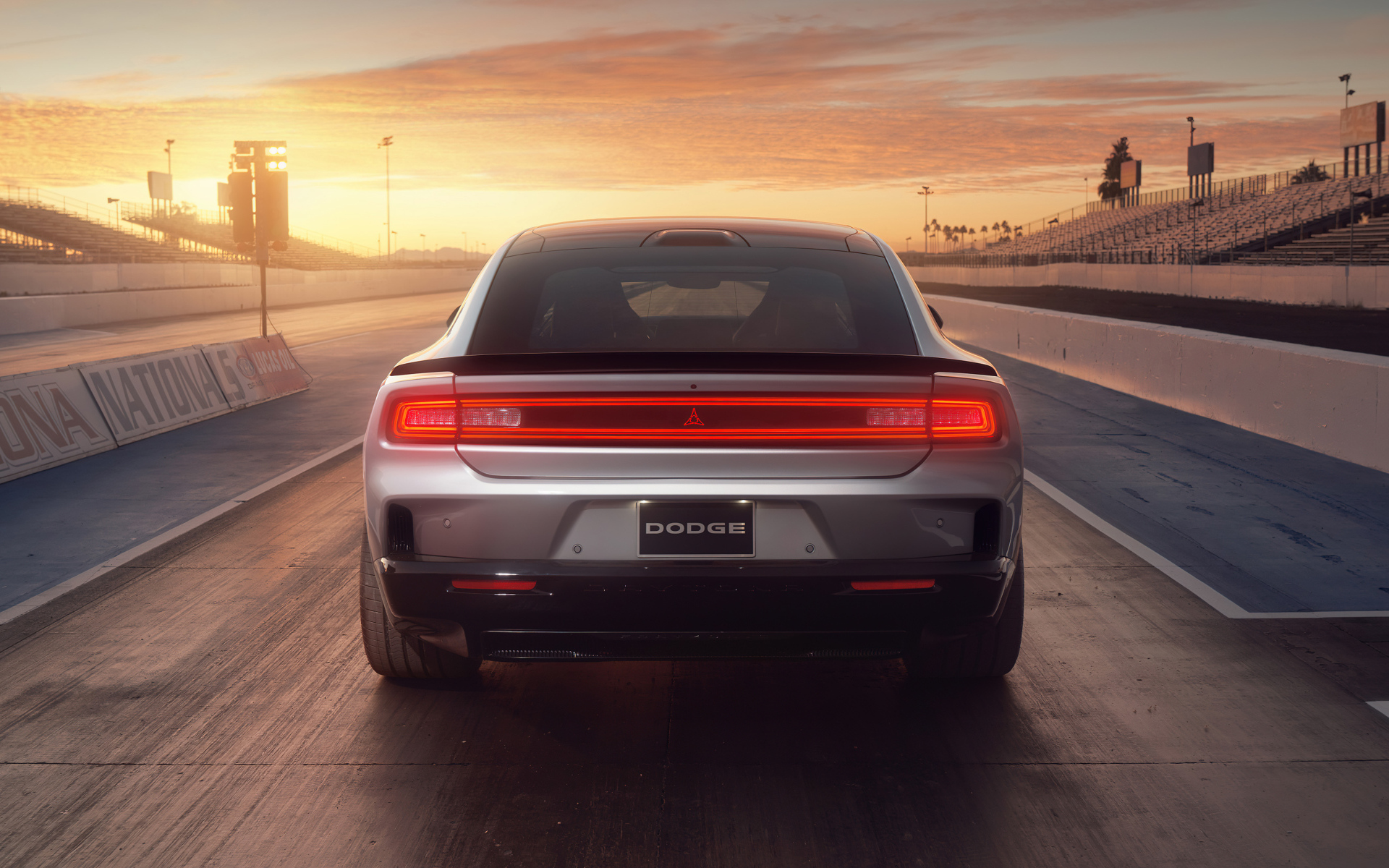 Вид сзади на автомобиль Dodge Charger Daytona Scat Pack 2024 года на закате