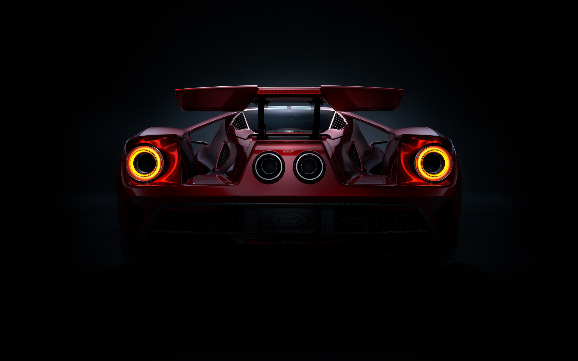 Вид сзади на автомобиль Ford GT  на черном фоне