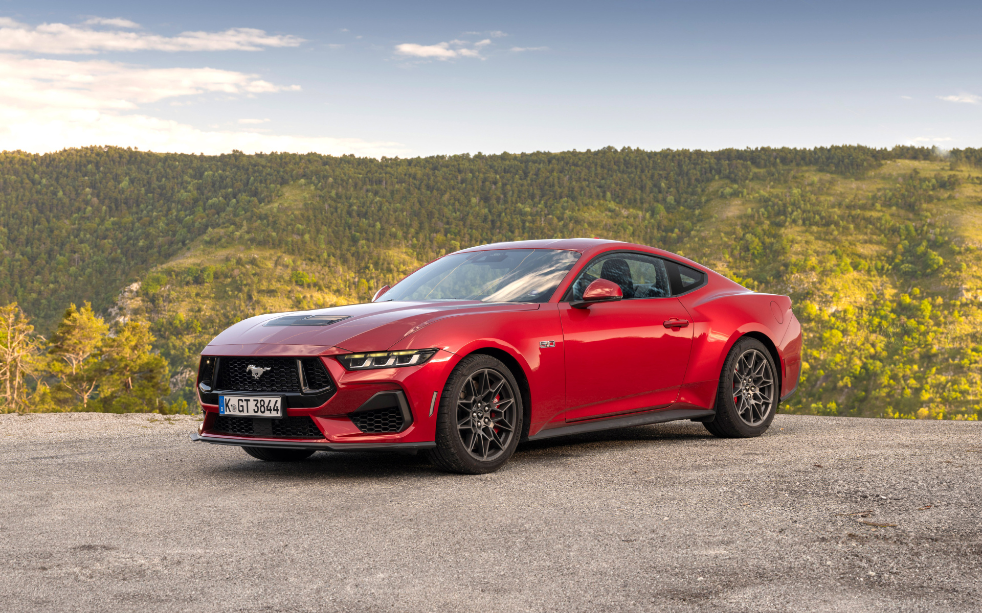 Красный автомобиль Ford Mustang GT 2024 года