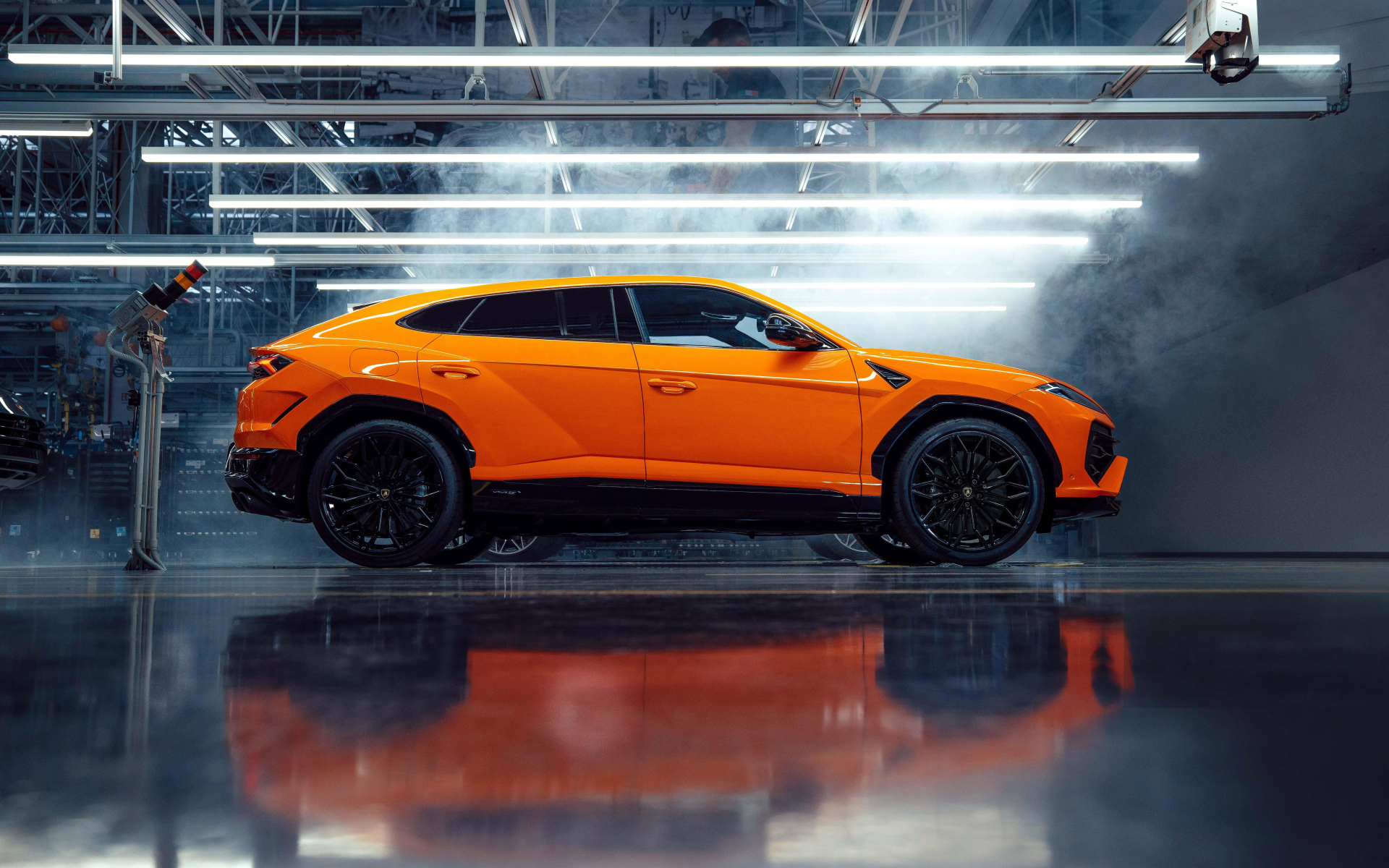 Оранжевый автомобиль Lamborghini Urus SE Plug-In Hybrid Super SUV вид сбоку