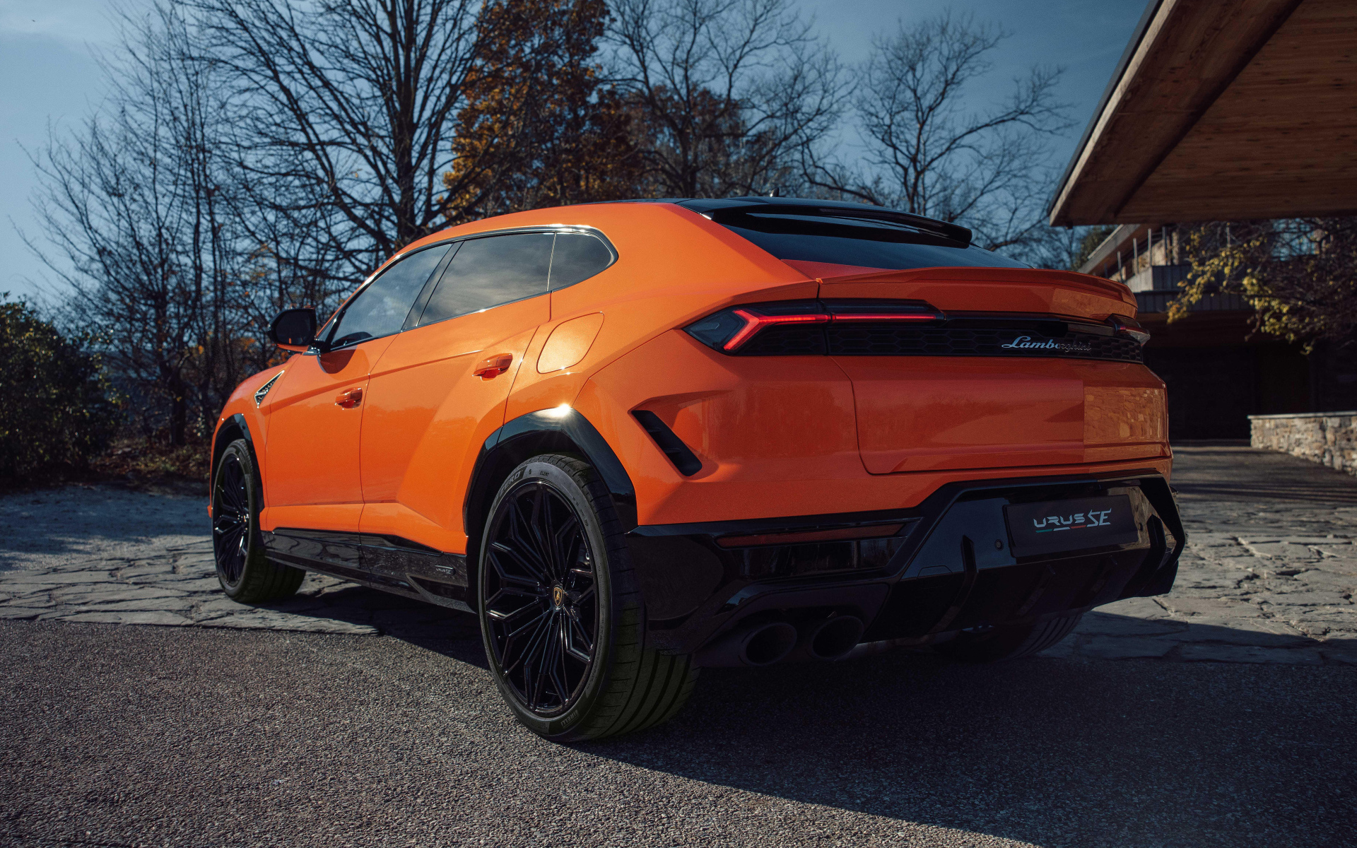 Вид сзади на оранжевый внедорожник Lamborghini Urus SE Plug-In Hybrid