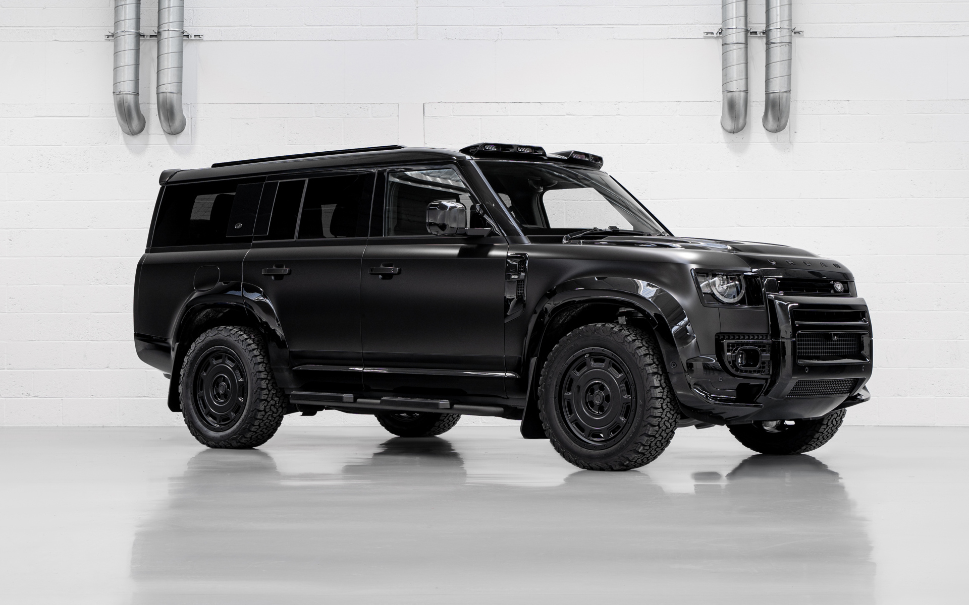 Большой черный автомобиль Land Rover Defender Widetrack 2024 года