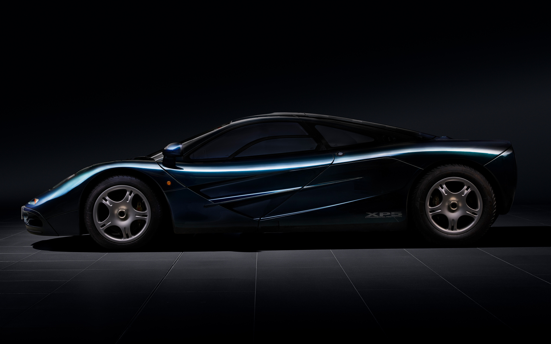 Вид сбоку на черный дорогой автомобиль McLaren F1