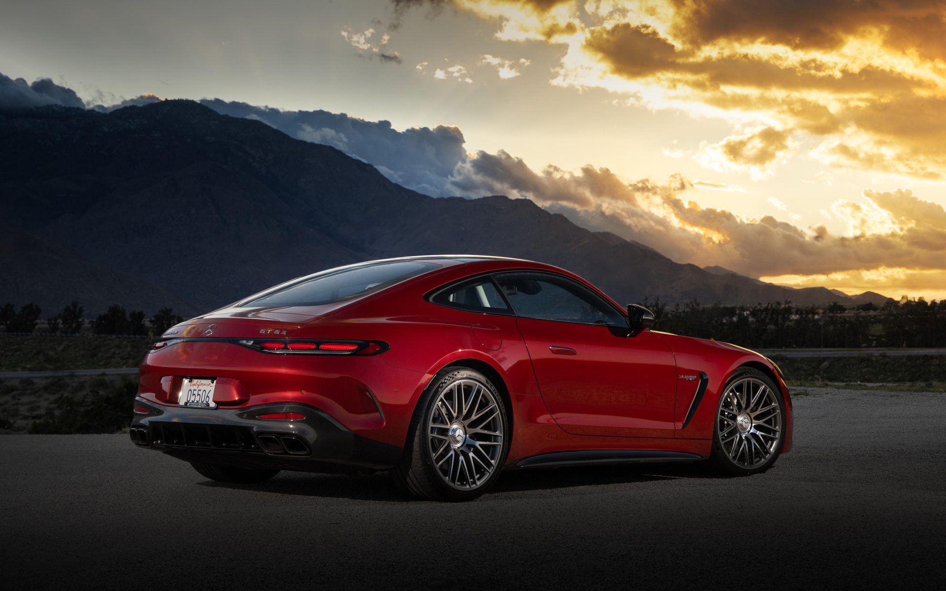 Вид сзади на красный автомобиль Mercedes-AMG GT 63 4MATIC+ 2024 года на закате