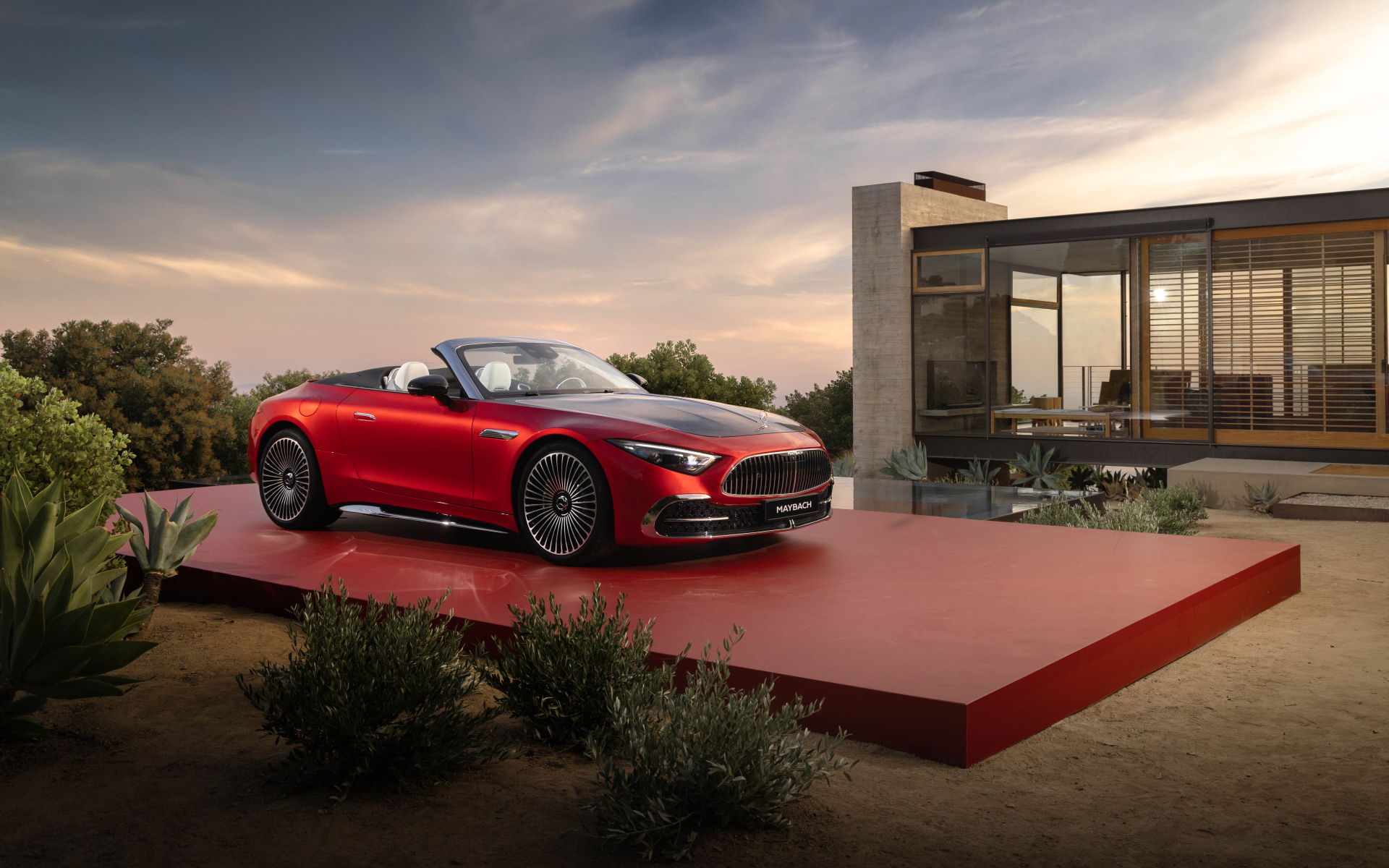 Красный автомобиль Mercedes-Maybach SL 680 Monogram Series 2024 года у дома