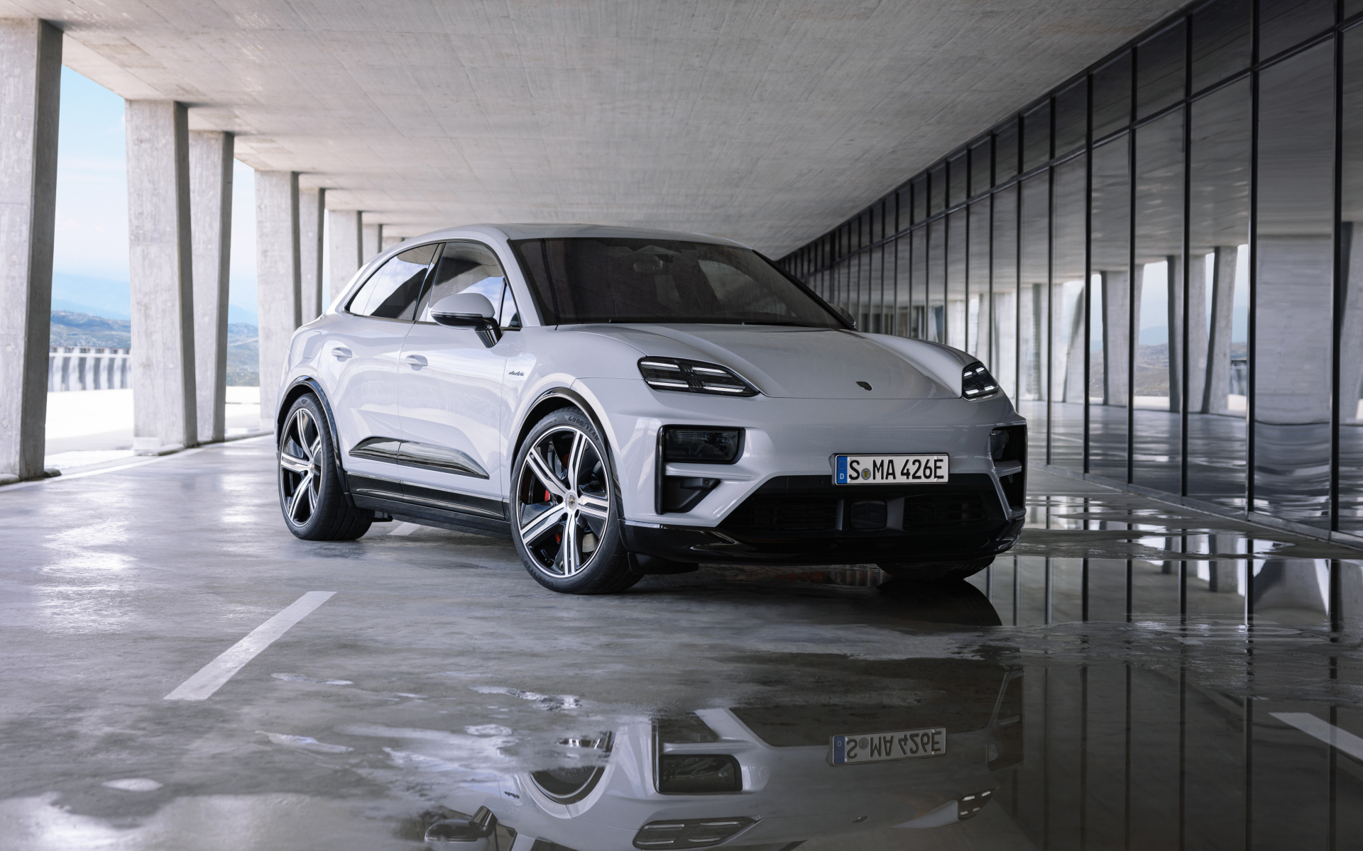 Большой Porsche Macan Turbo 2024 года у здания