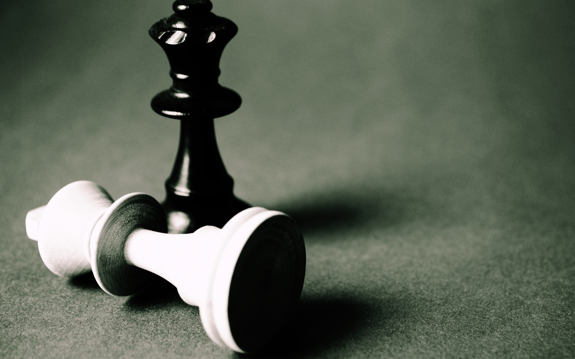 Черная и белая шахматные фигуры на сером столе