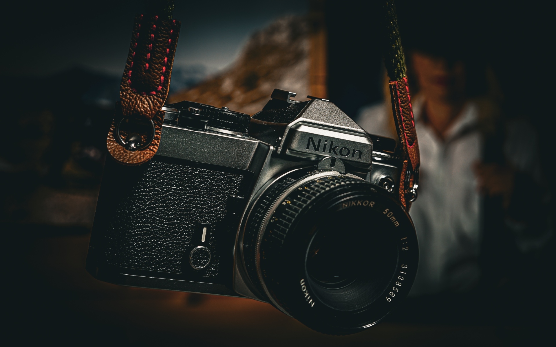 Черный фотоаппарат nikon на ремне