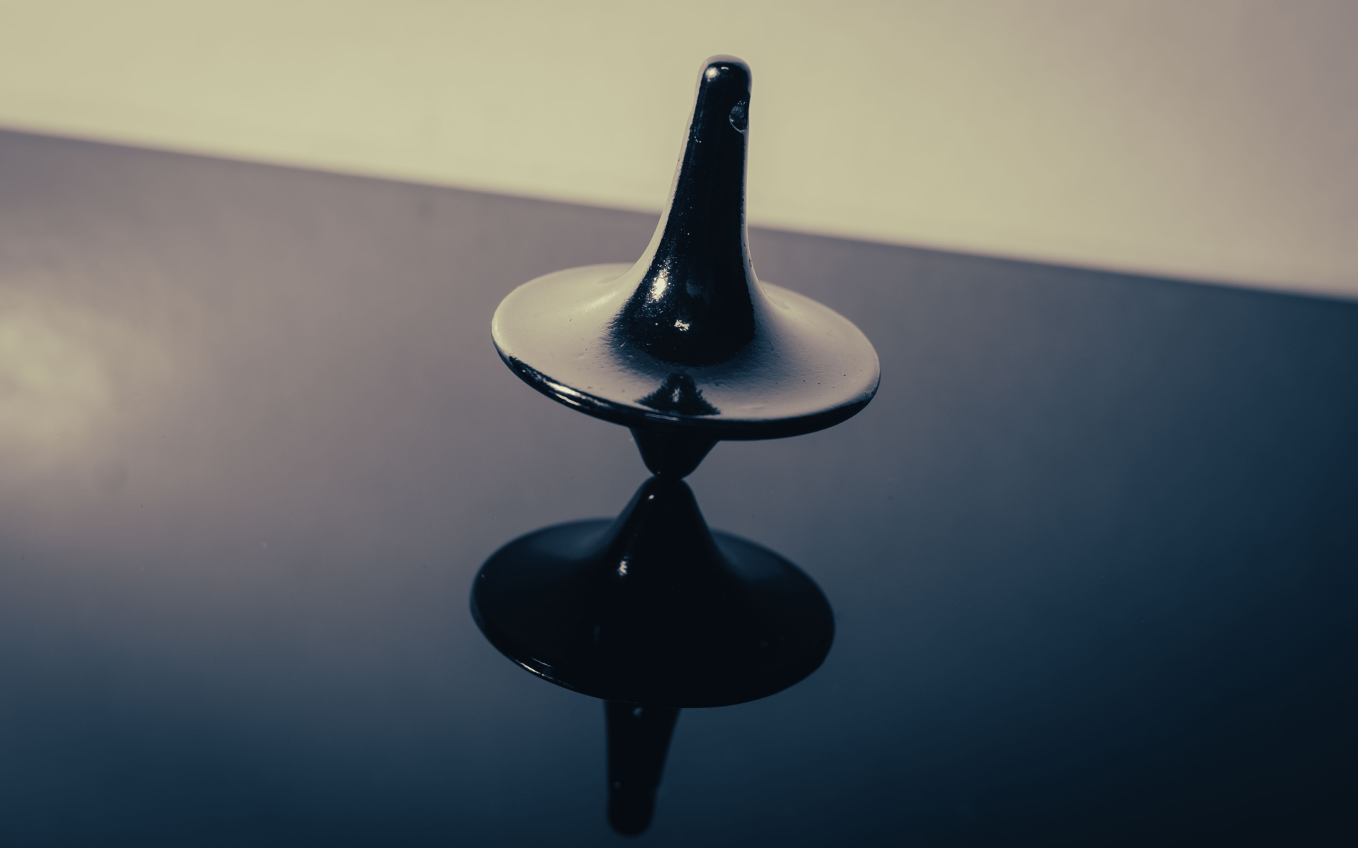 Черный волчок на ровной поверхности