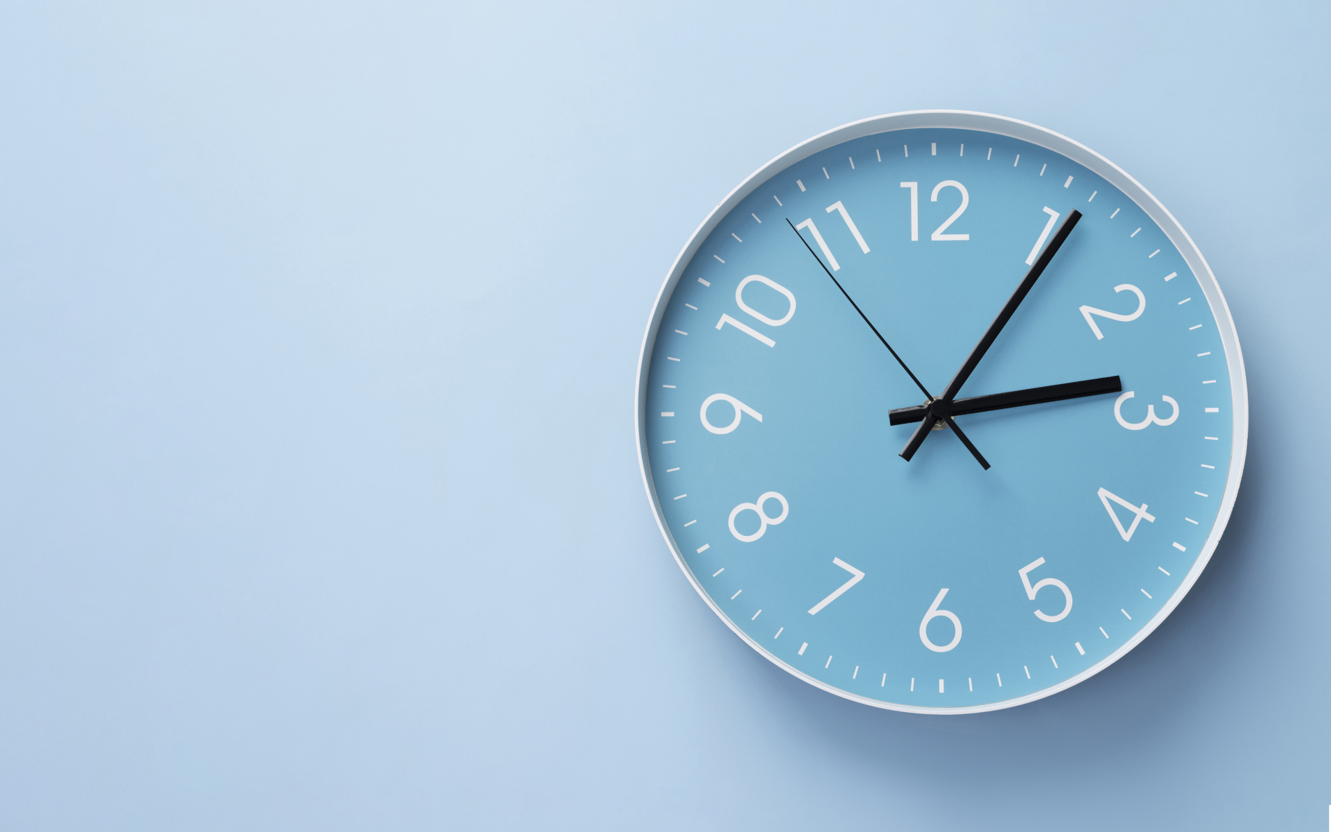 Круглые часы на голубом фоне крупным планом