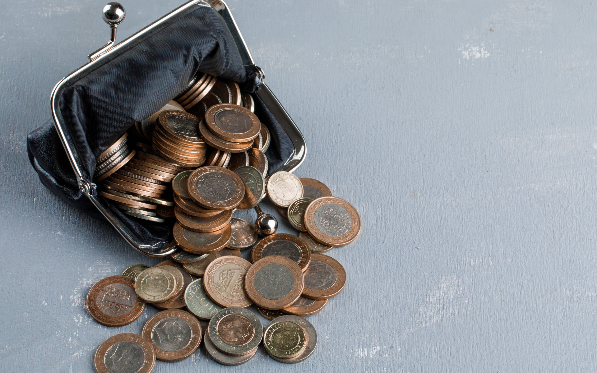 Кошелек с монетами на сером столе