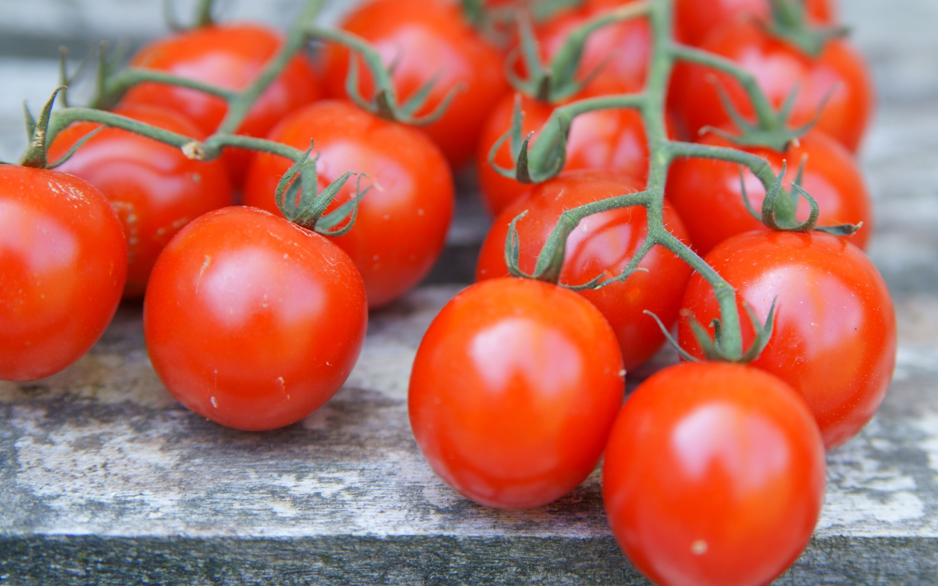 Веточки с красными помидорами на столе