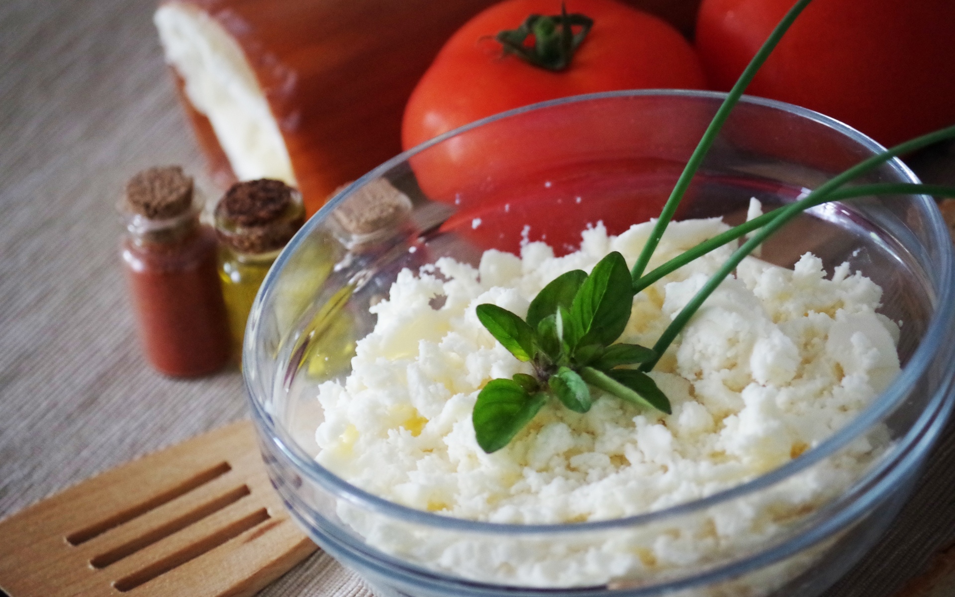 Творог в тарелке на столе с помидорами