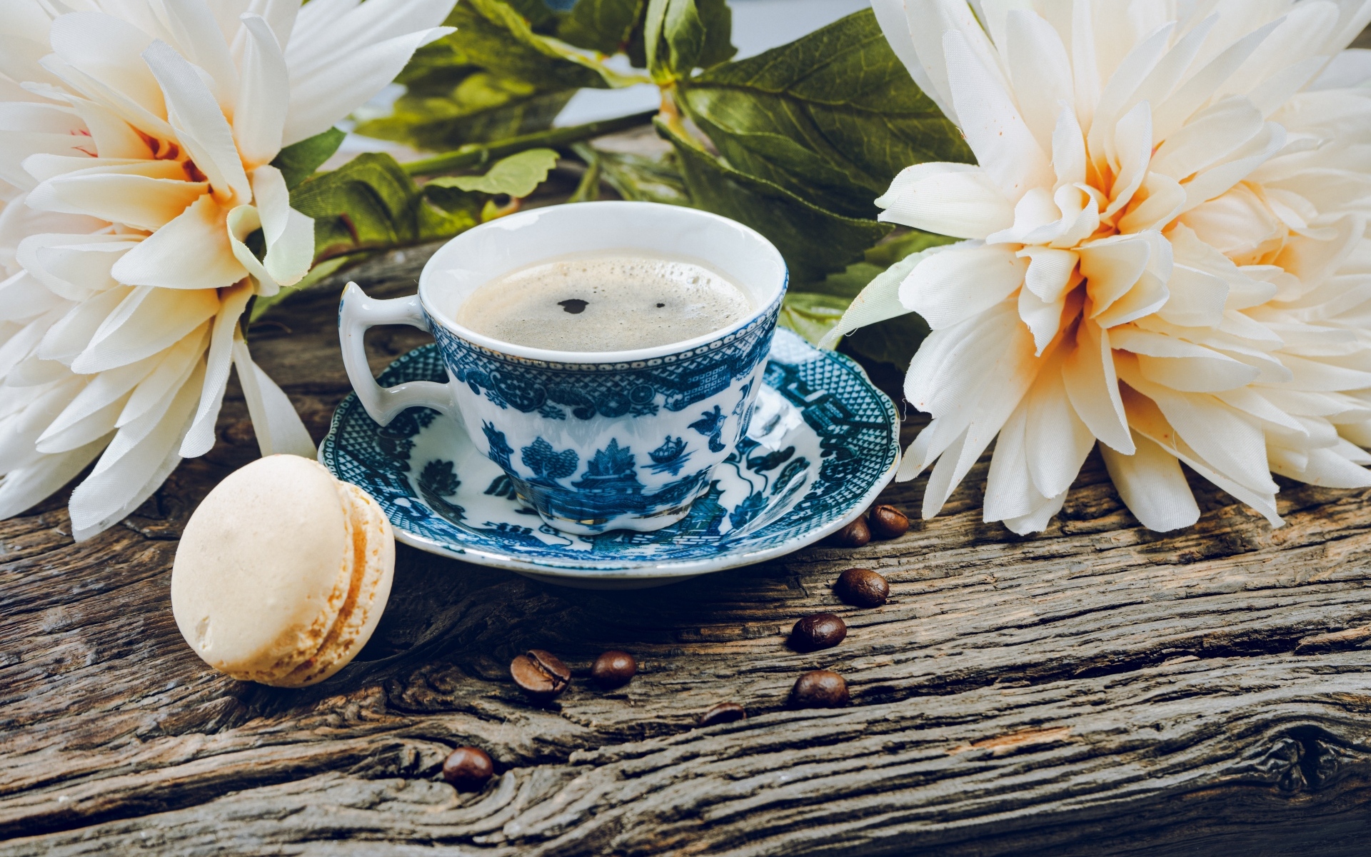 Чашка кофе с макарунами на столе с цветами