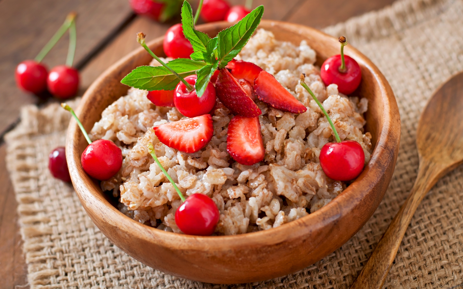 Овсяная каша с ягодами в деревянной миске