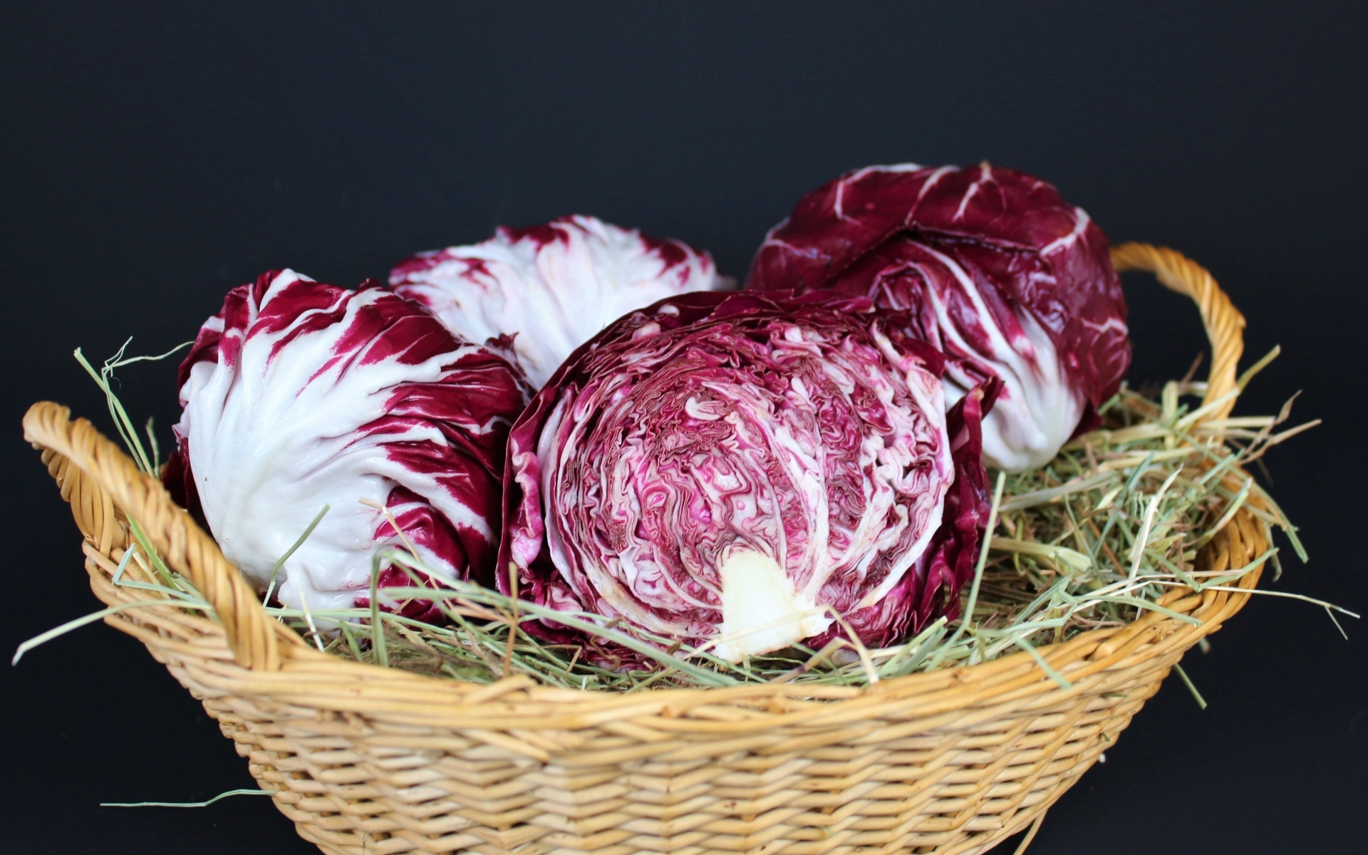 Красная капуста в корзине на черном фоне