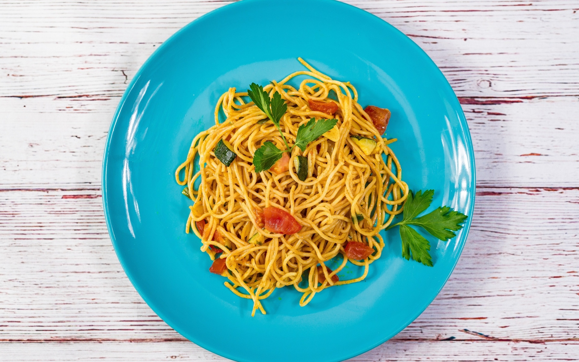 Спагетти с овощами  на голубой тарелке