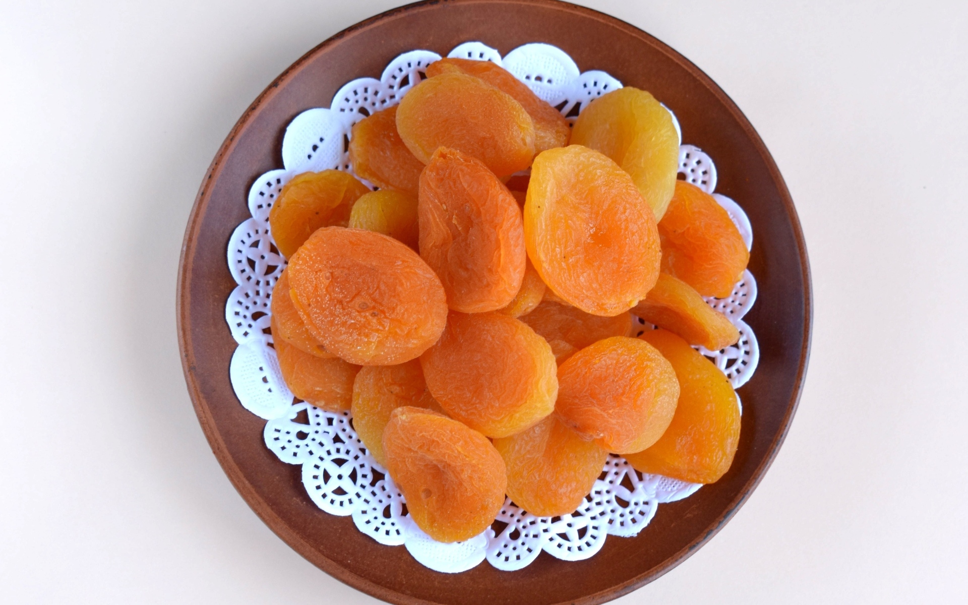 Курага с тарелке на сером фоне