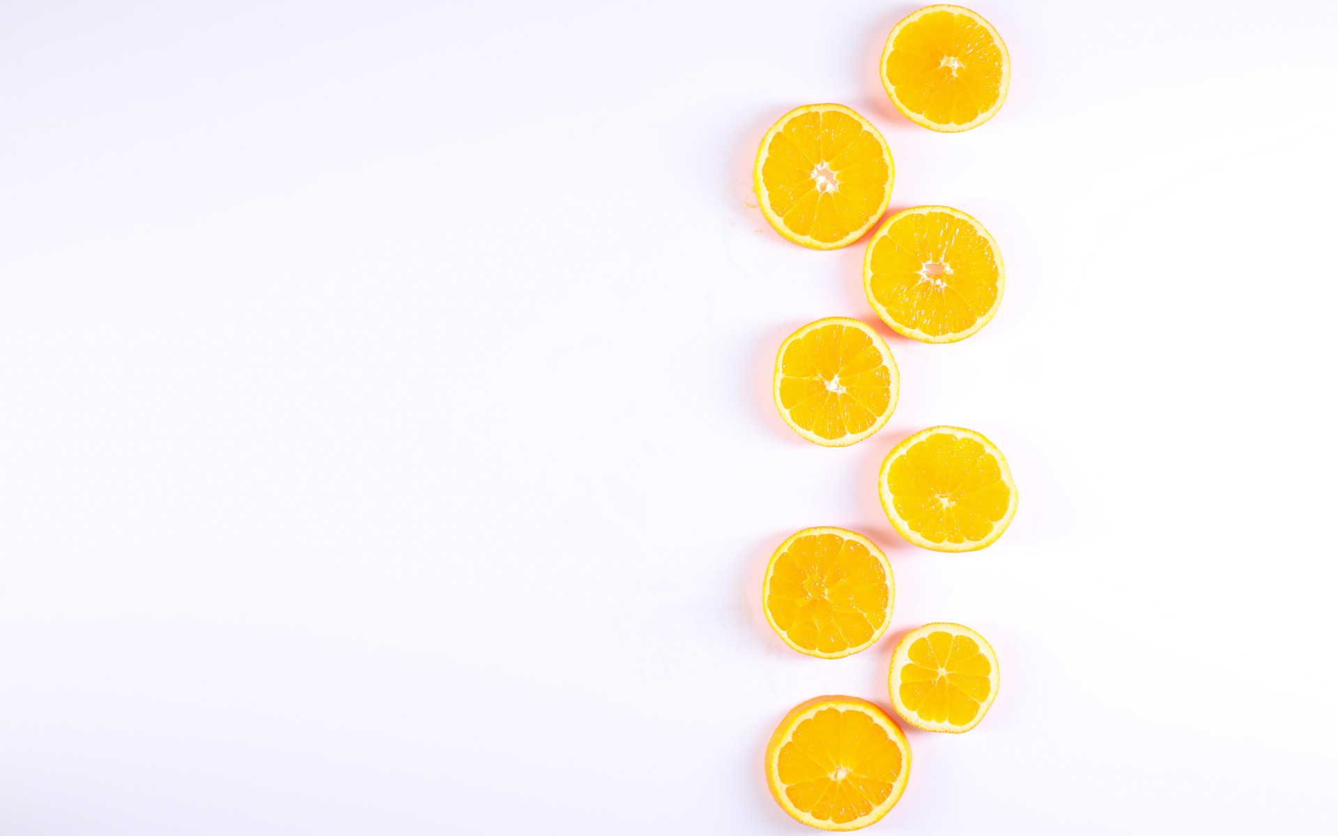 Много половинок лимона и апельсина на белом фоне