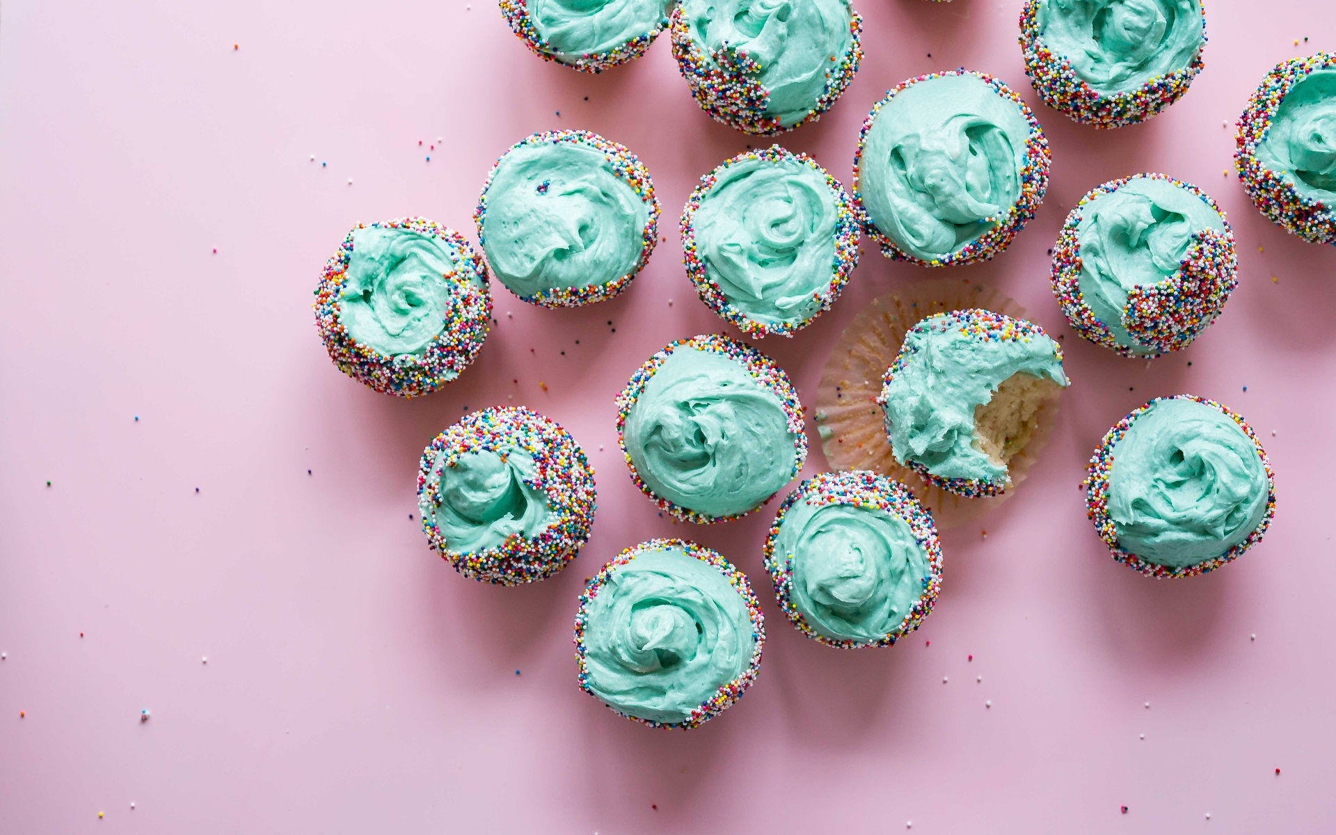 Аппетитные кексы с голубым кремом на розовом столе