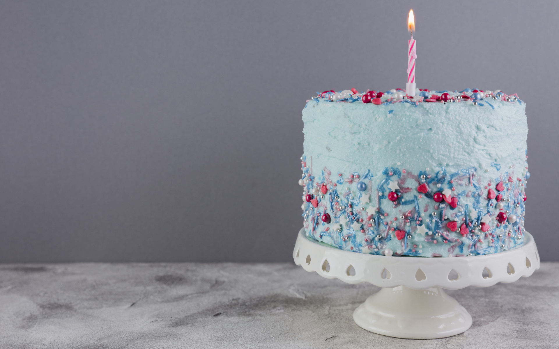 Праздничный торт в голубой глазури с одной свечкой