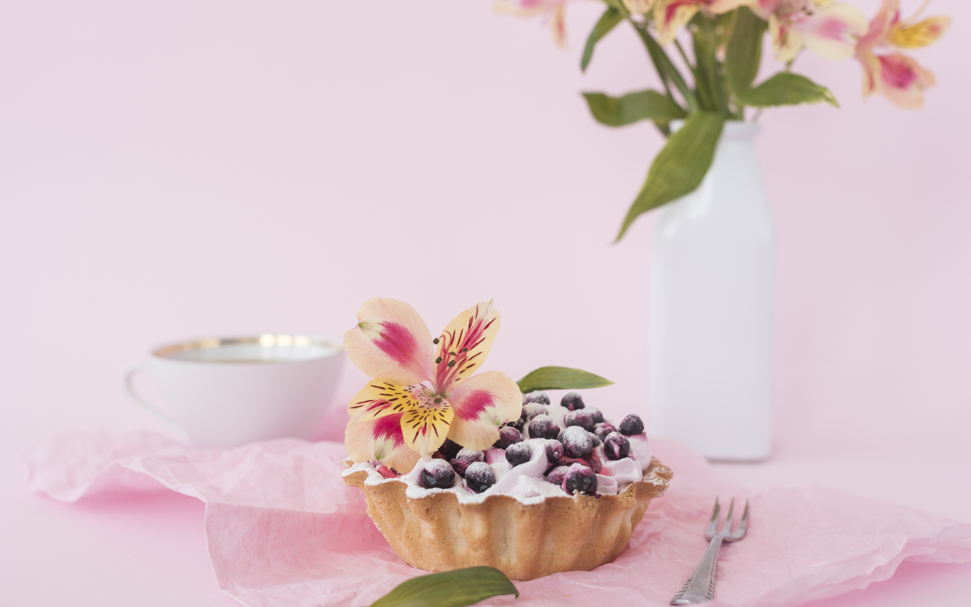 Черничное пирожное с цветами альстромерии на розовом фоне