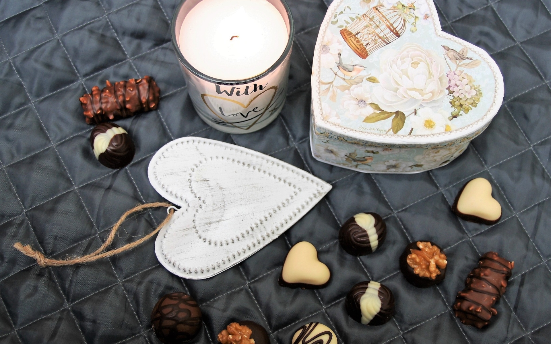 Коробка на кровати с конфетами и свечой