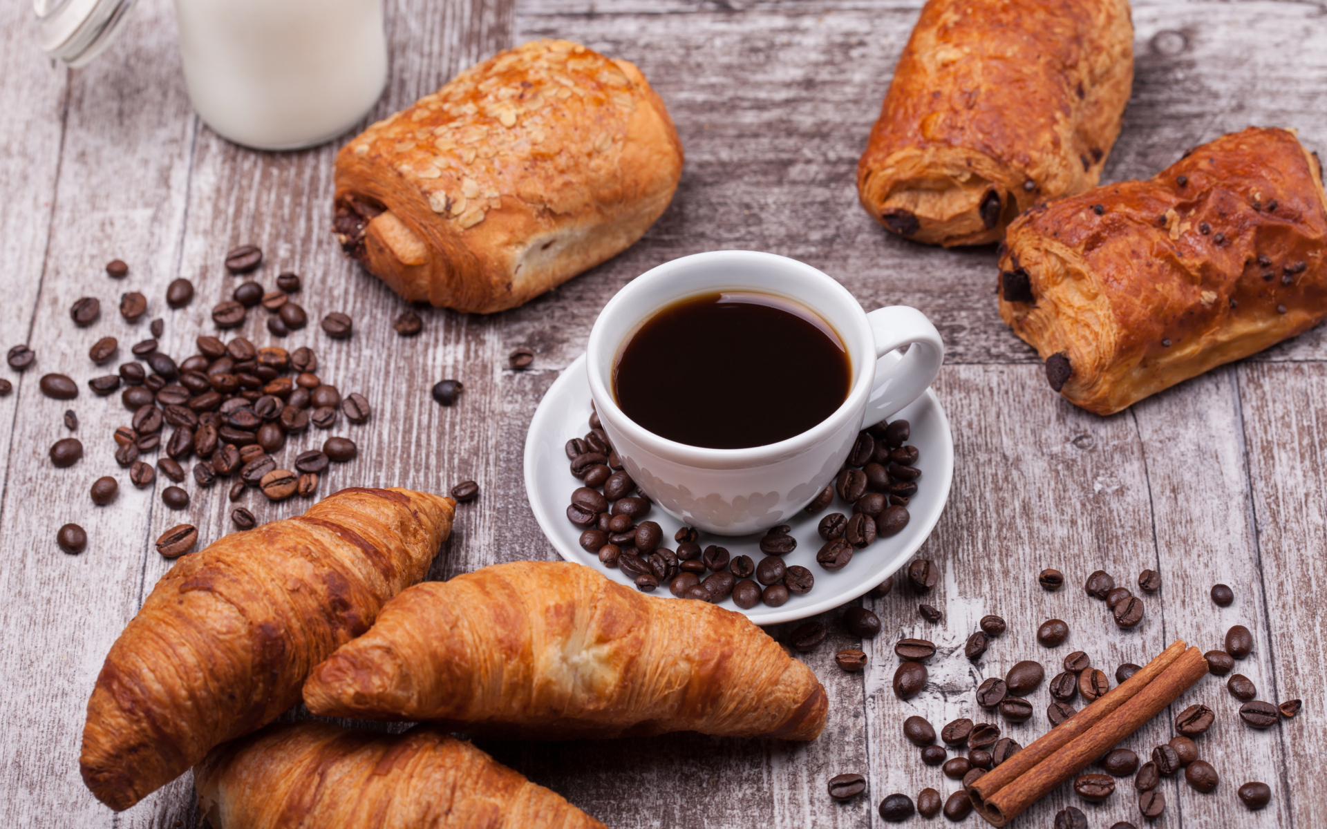 Кофе на столе с круассанами и зернами