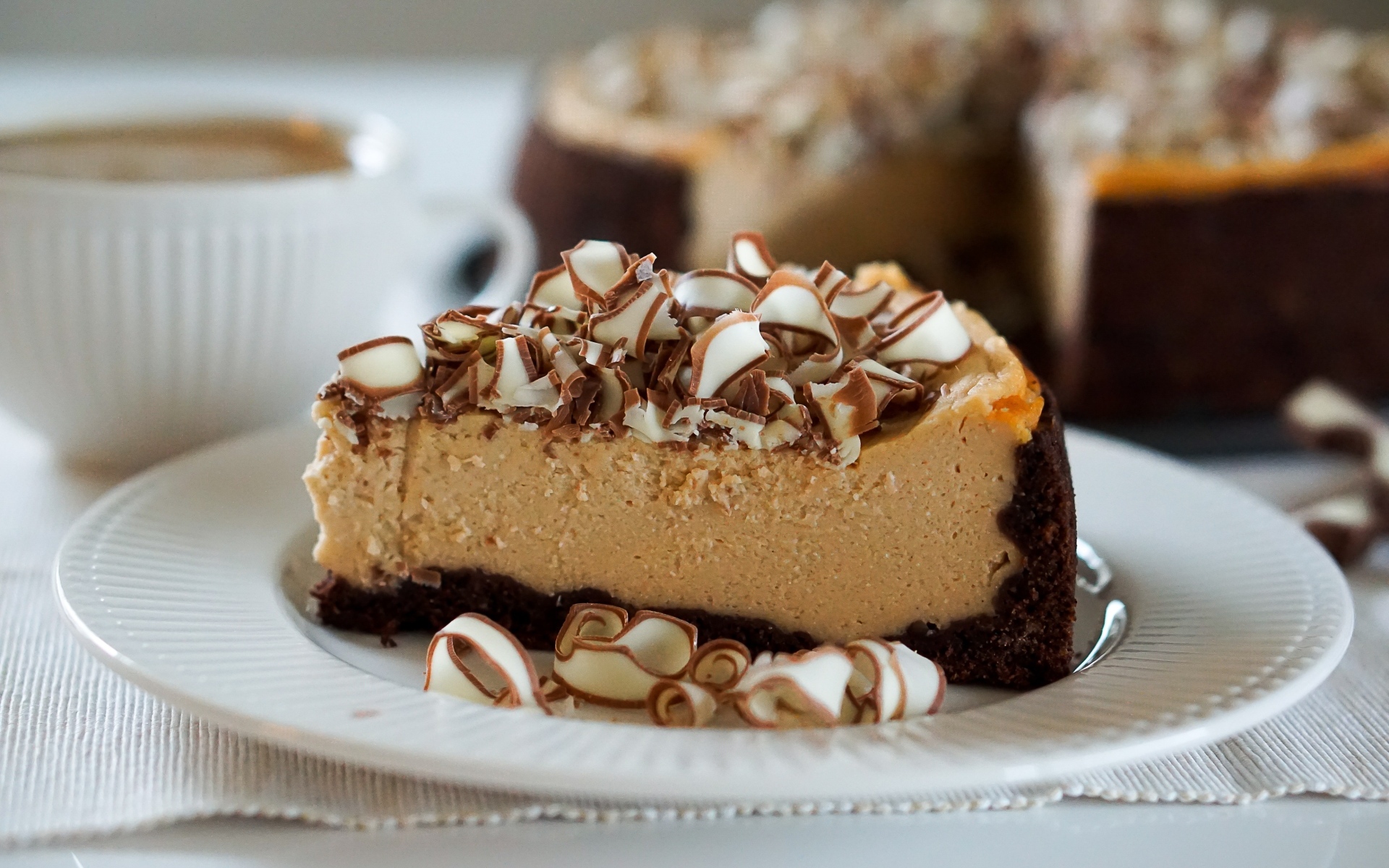 Кусок торта с шоколадной стружкой на белой тарелке