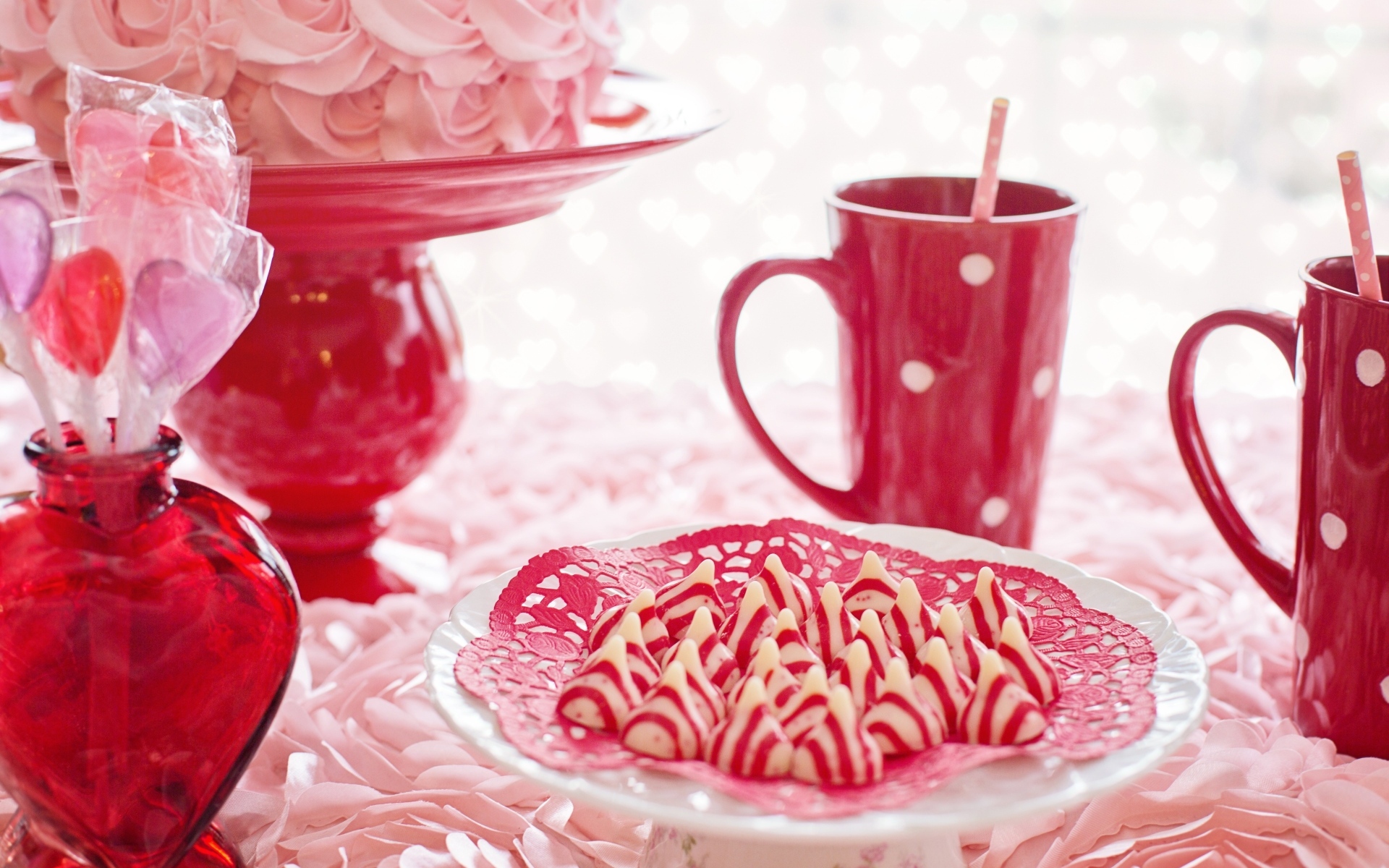 Сладкие розовые конфеты на столе с чаем и тортом