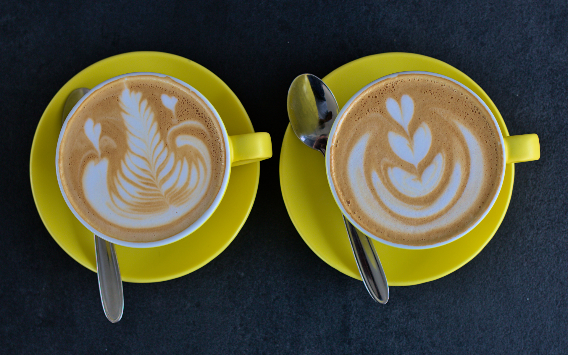 Две большие чашки капучино с рисунками на пене